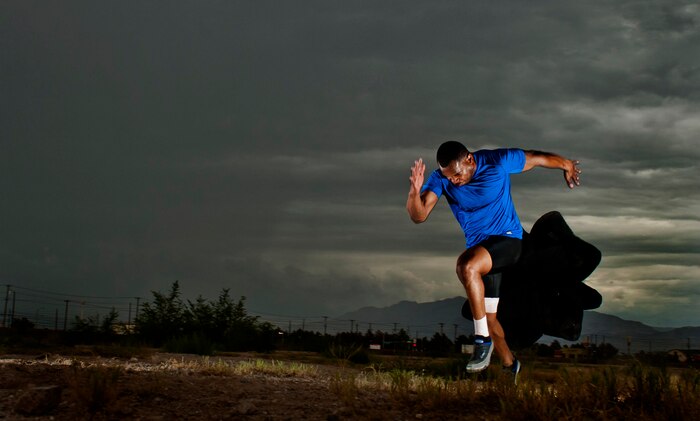 U.S. Air Force Staff Sgt. Yarbrough Bloomfield III, 99th Logistics Readiness Squadron vehicle dispatcher, trains with a parachute Sept. 11, 2013, at Nellis Air Force Base, Nev. The parachute provides resistance which helps build muscle strength to make Bloomfield stronger and faster. (U.S. Air Force photo by Senior Airman Daniel Hughes)