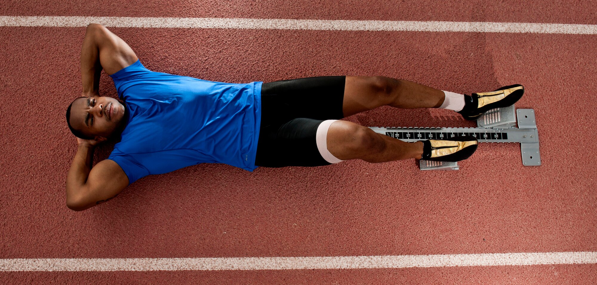 U.S. Air Force Staff Sgt. Yarbrough Bloomfield III, 99th Logistics Readiness Squadron vehicle dispatcher, lies on the track Sept. 11, 2013, at Nellis Air Force Base, Nev. Bloomfield runs the 100 meter dash, and his best time was recorded at 10.1 seconds in a high school meet. The Men’s World Record is 9.58 held by Usian Bolt and the Women’s World Record is 10.49 held by Florence Griffith. (U.S. Air Force photo by Senior Airman Daniel Hughes)