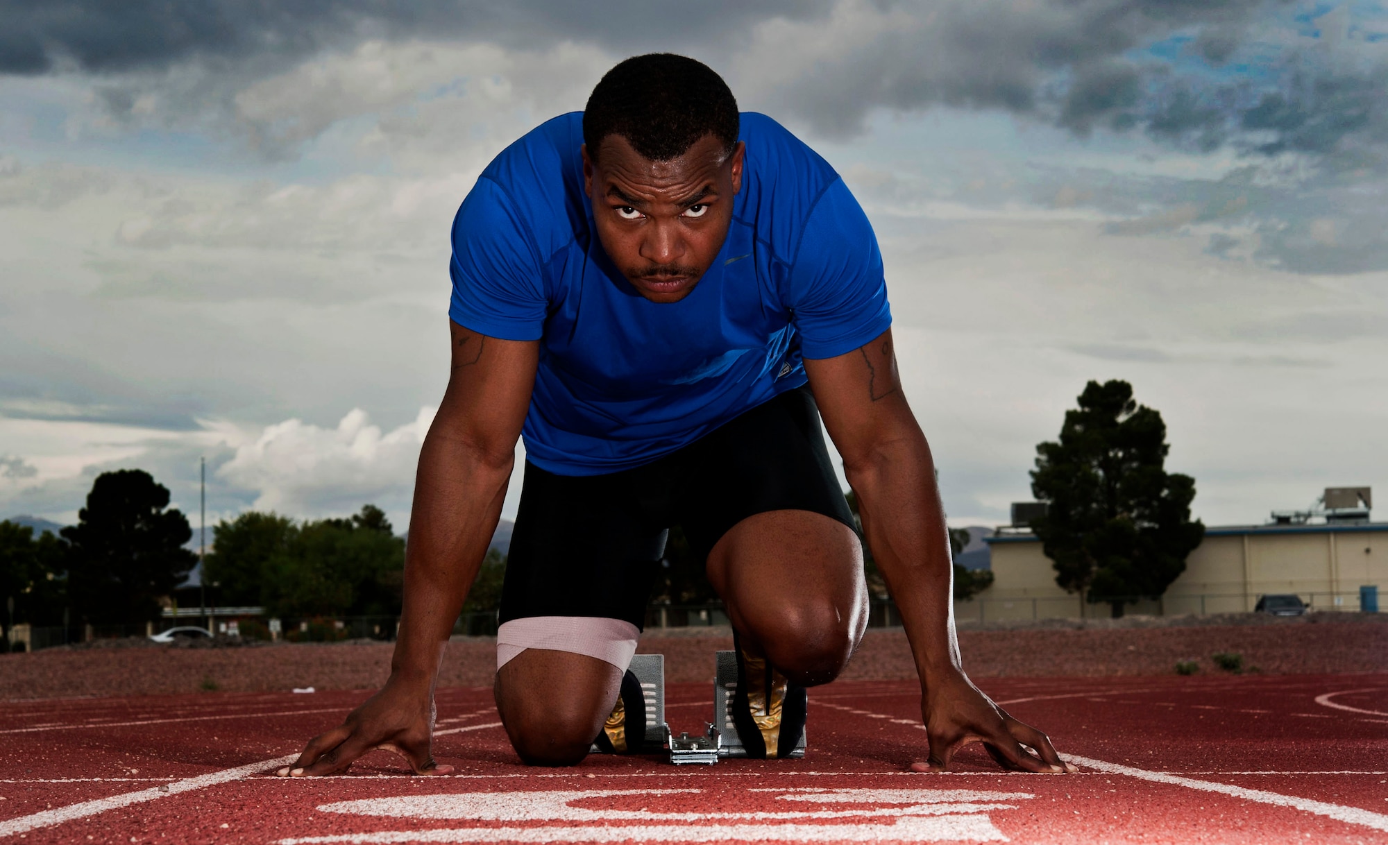 U.S. Air Force Staff Sgt. Yarbrough Bloomfield III, 99th Logistics Readiness Squadron vehicle dispatcher, lines up at the track starting line Sept. 11, 2013, at Nellis Air Force Base, Nev. Bloomfield ran track in high school and is training to run the 100 meter dash for the Air Force team next summer. (U.S. Air Force photo by Senior Airman Daniel Hughes)