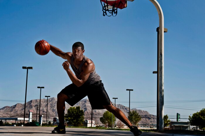 U.S. Air Force Senior Airman Nathaniel Mills, 99th Security Forces Squadron patrolman, performs a crossover dribble while playing basketball Sept. 18, 2013, at a court in Las Vegas. Mills has been training to fine tune his game before trying out for the Air Force basketball team in October. (U.S. Air Force photo by Senior Airman Daniel Hughes)