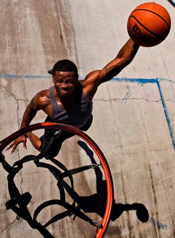 U.S. Air Force Senior Airman Nathaniel Mills, 99th Security Forces Squadron patrolman, dunks a basketball Sept. 18, 2013, at a basketball court in Las Vegas. Mills, whose passion for basketball started in 1995 while watching the Chicago Bulls play, is now training to try out for the Air Force basketball team in October. (U.S. Air Force photo by Senior Airman Daniel Hughes)