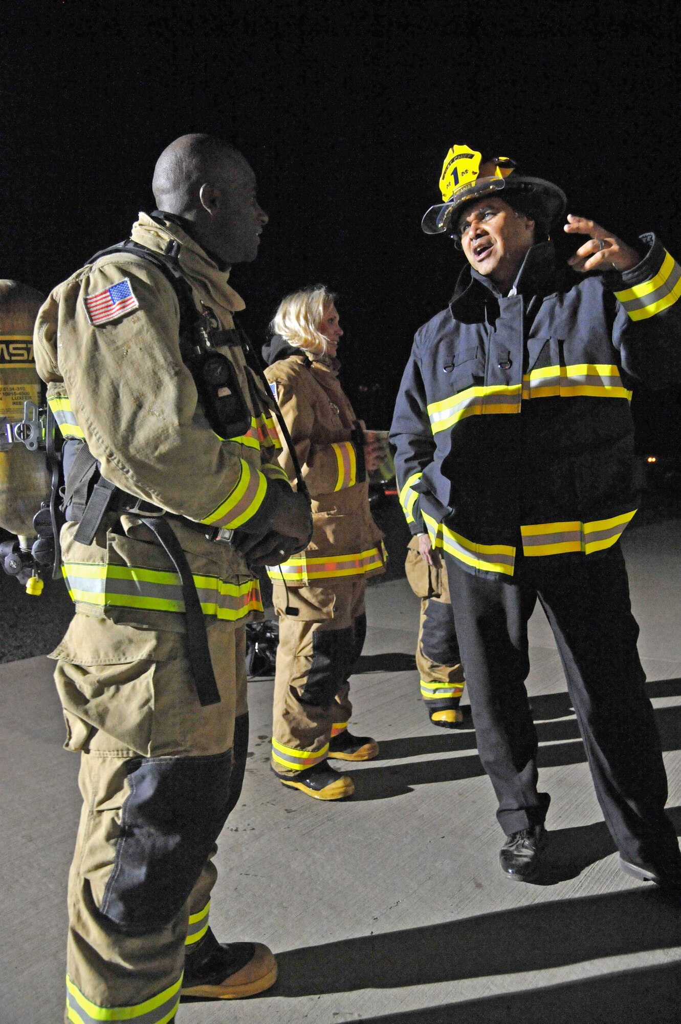 Col. Brian Hill, 92nd Air Refueling Wing vice commander, speaks with Kimo Kuheana, 92nd Civil Engineer Squadron fire chief, during a night training mission at Fairchild Air Force Base, Wash., Sept. 16, 2013. Hill participated in the training mission as part of his immersion with squadrons around the base to become familiar with Airmen and their daily duties. (U.S. Air Force photo by Senior Airman Mary O'Dell/Released)