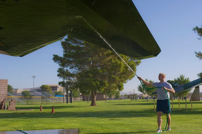 Tech. Sgt. Kevin Waggoner, 414th Combat Training Squadron maintenance NCO in charge, rinses an F-117A Nighthawk static display at Freedom Park Sept. 18, 2013, at Nellis Air Force Base, Nev. The aircraft at Freedom Park require a fresh water rinse once a year to help preserve the paint on the aircraft. (U.S. Air Force photo by Senior Airman Matthew Lancaster)