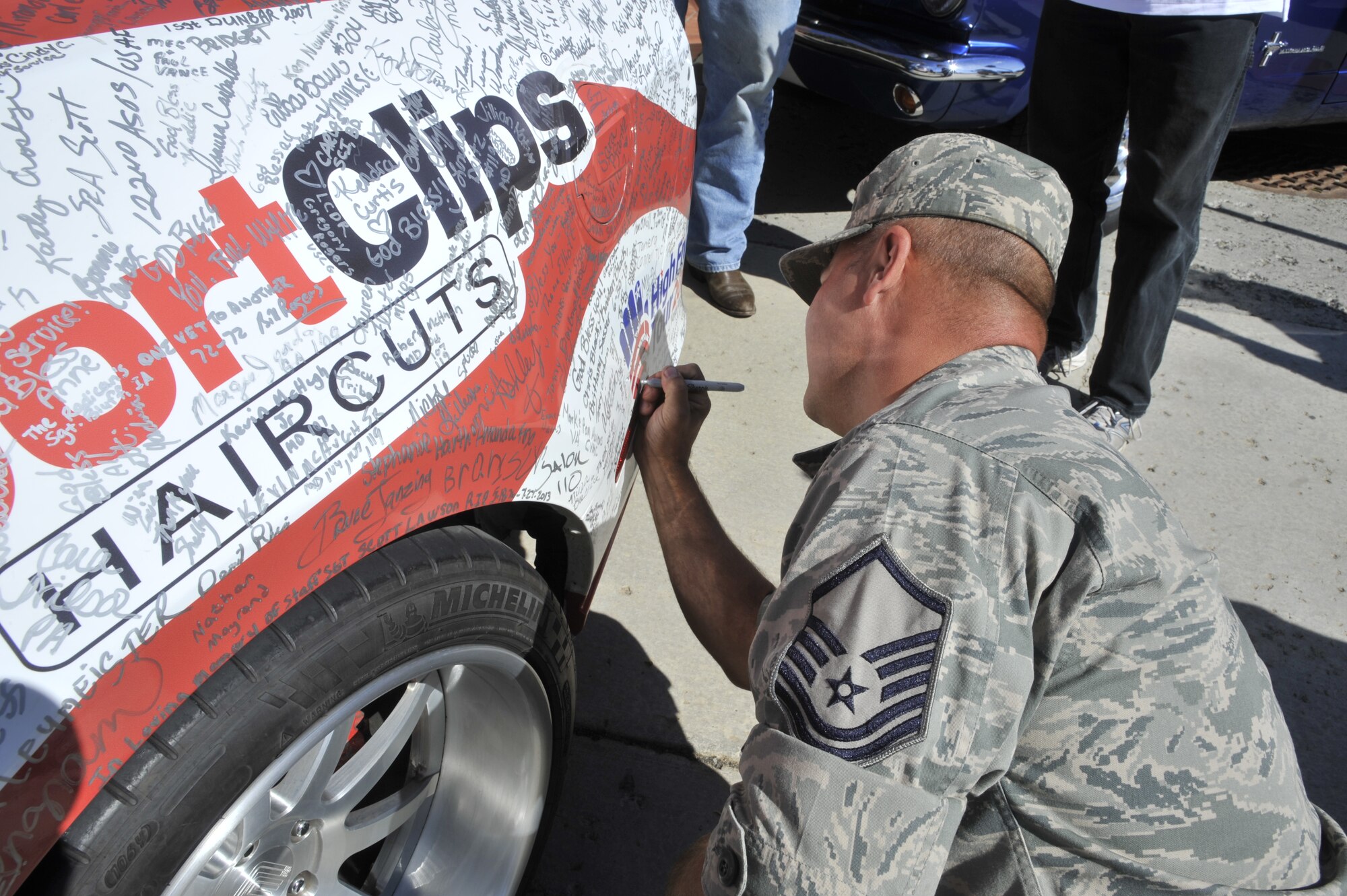 Master Sgt. Jack Zappone, 141st Logistics Readiness Squadron heavy equipment mechanic, signs the Wounded Warriors Family Support Mustang at Fairchild Air Force Base, Wash., Sept. 19, 2013. During a five-month period, the 2013 Mustang GT500 “Super Snake” will cover 21,000 miles, traveling to more than 60 cities and stopping in 48 states, collecting thousands of signatures along the way. This car will be auctioned off at the 2014 Barrett-Jackson Auto Auction with all proceeds going to the Wounded Warrior Project. (U.S. Air Force photo by Senior Airman Mary O’Dell/Released)