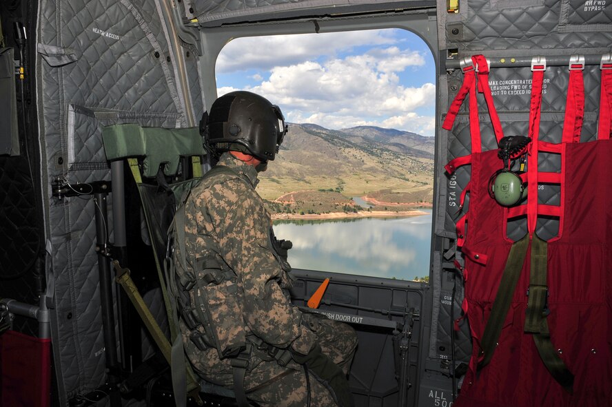 U.S. Army PVT Ben Stocker, CH-47 Chinook helicopter Crew Chiefs with the 2nd Battalion, 135th General Support Aviation Battalion, Colorado National Guard, looks out over Horsetooth Reservoir west of Fort Collins Colo. as they fly towards an area effected by the flood waters to deliver food and water to Colorado residents that have been effected by the floods but are allowed to stay with their homes, Sept. 17, 2013.  What is being dubbed “Operation Centennial Raging Waters” is likely the biggest rotary-wing airlift mission since Hurricane Katrina and has become a complete neighbors helping neighbors effort with state national guards from Colorado and Wyoming, Active duty units from Colorado as well as search and rescue units from all over the country. (U.S. Air National Guard photo by Tech. Sgt. Wolfram M. Stumpf/RELEASED)