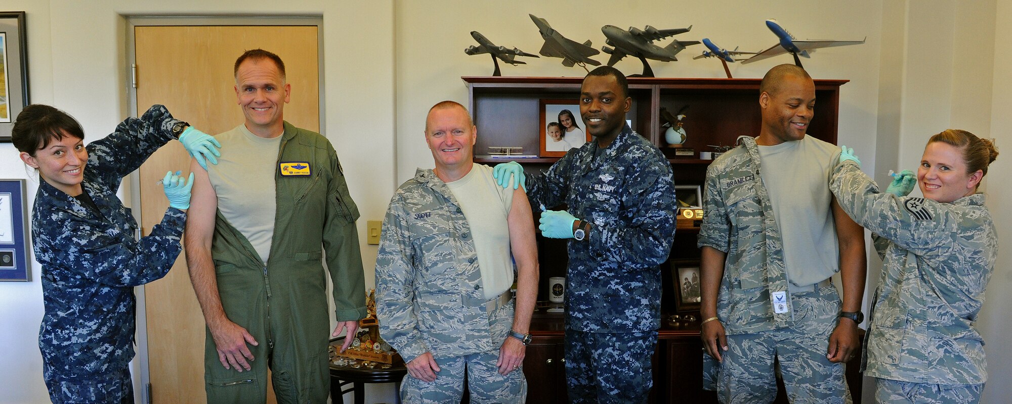 From left to right, U.S. Navy Hospital Corpsman Second Class Mishell Miyashiro from the Navy Health Clinic Hawaii Preventive Medicine (NHCH), Col. John Roscoe, 15th Wing commander, Col. Terry Scott, 15th Wing vice commander, U.S. Navy Hospital Corpsman Second Class Miguel May, Chief Master Sgt. Leslie Bramlett, 15th Wing command chief, and Staff Sgt. Aimee Braxton, 15th Medical Operations Squadron NCO in Charge of immunizations prepare to administer flu vaccinations to 15 WG senior leaders at 15th Wing headquarter building, Joint Base Pearl Harbor-Hickam, Hawaii, Sept. 4, 2013. An annual seasonal flu vaccine (either the flu shot or the nasal-spray flu vaccine) is the best way to reduce the chances that you will get seasonal flu and lessen the chance that you will spread it to others.  (U.S. Air Force photo/Tech. Sgt. Jerome S. Tayborn) 