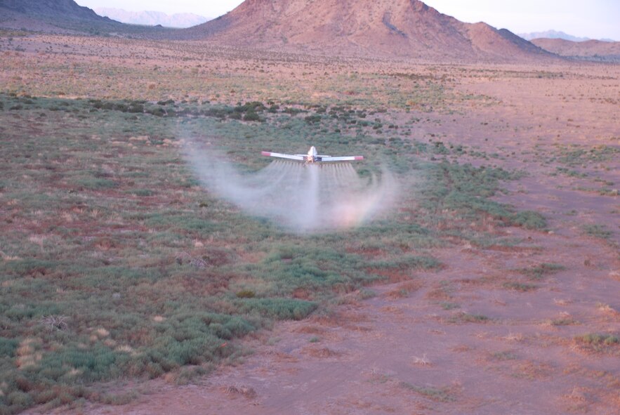 Control of exotic, invasive vegetation is a resource management priority at the Barry M. Goldwater Range-East in southwestern Arizona.  Shown here, a fixed-wing aircraft sprays herbicide over a large monotypic stand of Russian Thistle, also known as tumbleweed.  Photo: R. Whittle