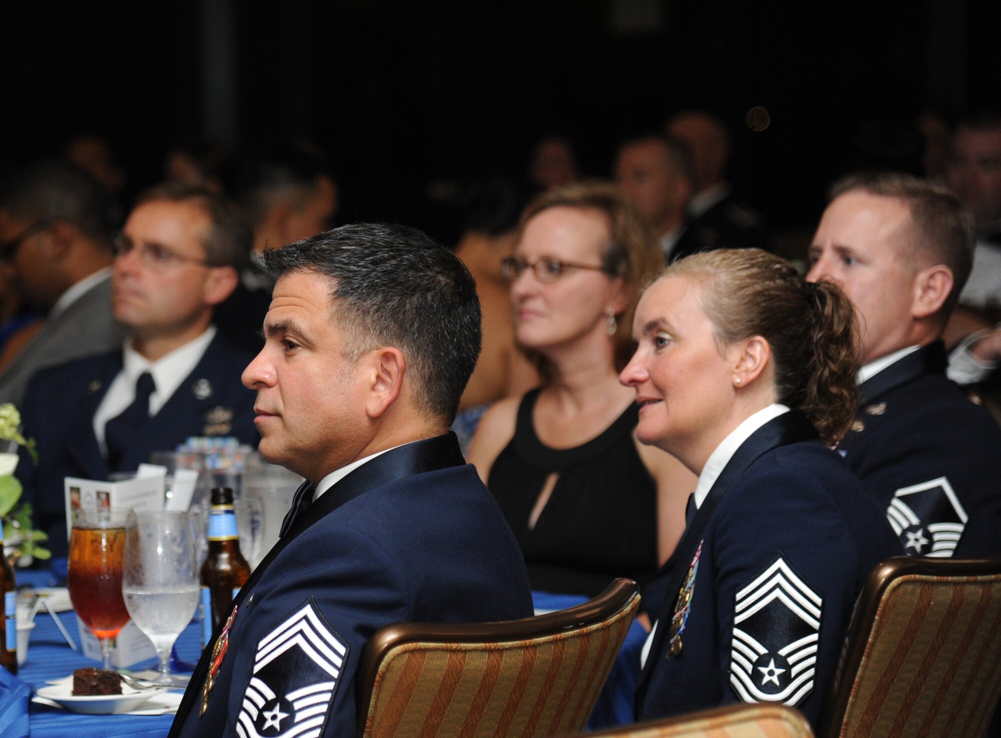 Chief Master Sgt. Eli Santos, 81st Training Support Squadron, and his wife, Retired Chief Master Sgt. Roxann Santos, listen to Retired Col. Carlyle Harris, former prisoner of war, make remarks as the guest speaker during the Air Force’s 66th Birthday Ball on Sept. 21, 2013, at Keesler Air Force Base, Miss. The event, sponsored by the Air Force Association, John C. Stennis Chapter #332, also celebrated the 81st Training Wing’s 20th anniversary.  (U.S. Air Force photo by Kemberly Groue)