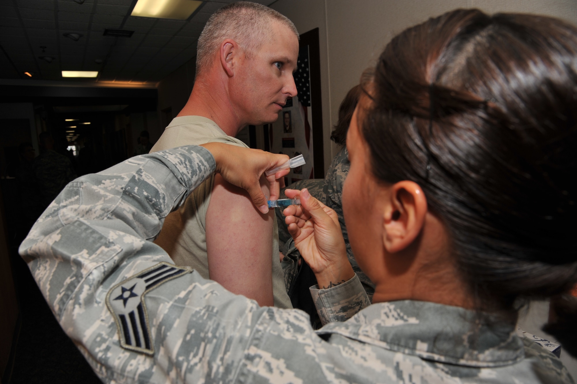 Senior Master Sgt. John Facemire, 377th Security Forces Squadron operations superintendent , receives the flu shot from Senior Airman Heather Boiles, 377th Medical Operations Squadron. The flu vaccination, both in shot and mist form, is available at the 377th Medical Group's Immunization Clinic. (Photo by Ken Moore) 