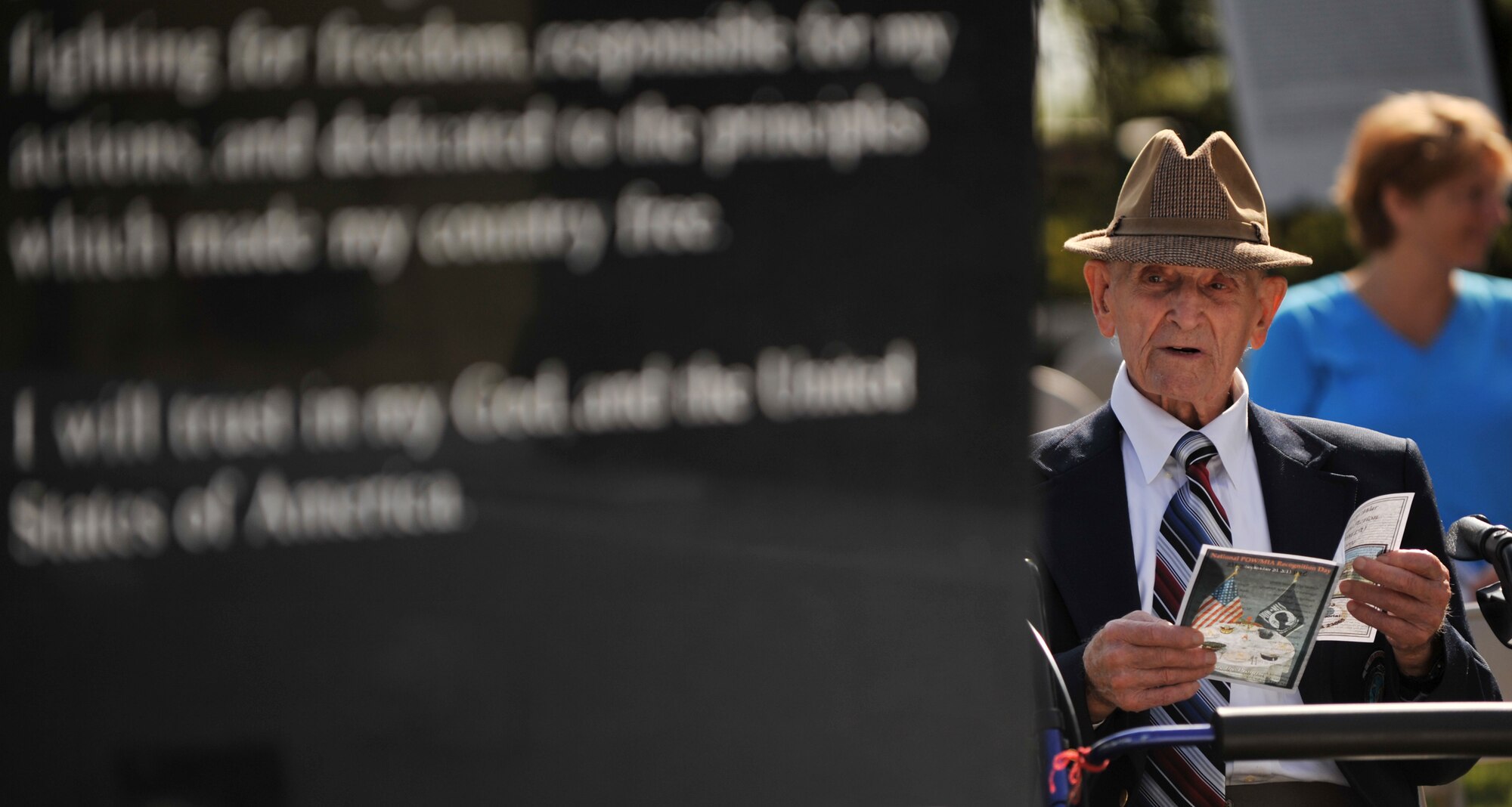 Retired U.S. Air Force Chief Master Sgt. Alcide Benini, World War II veteran and Bataan Death March survivor, glances up from reading the program for the 2013 POW/MIA Recognition Day ceremony on Langley Air Force Base, Va., Sept. 20, 2013. Benini was captured April 7, 1942 and spent 40 months as a Japanese POW. (U.S. Air Force photo by Staff Sgt. Jarad A. Denton/Released)