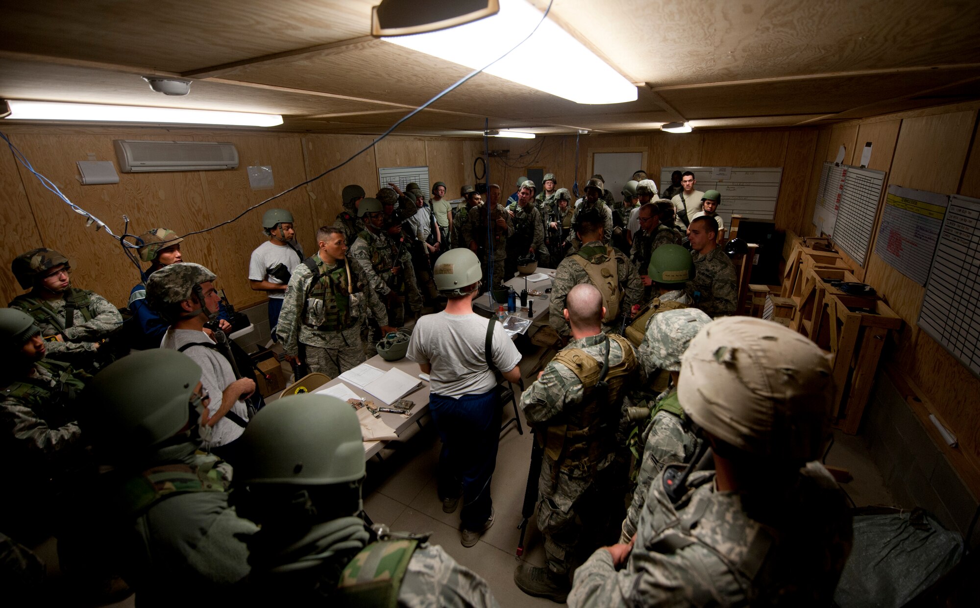 U.S. Air Force Airmen from the 726th Air Control Squadron gather at the mobile operating air base command post Sept. 17, 2013, at Mountain Home Air Force Base, Idaho. Airmen from the 726th ACS discussed how an exercise scenario played out during an after-action review. Understanding what was done incorrectly enables them to fix those problems, promoting success in future exercise scenarios or future deployments. (U.S. Air Force photo by Airman 1st Class Brittany A. Chase/Released)