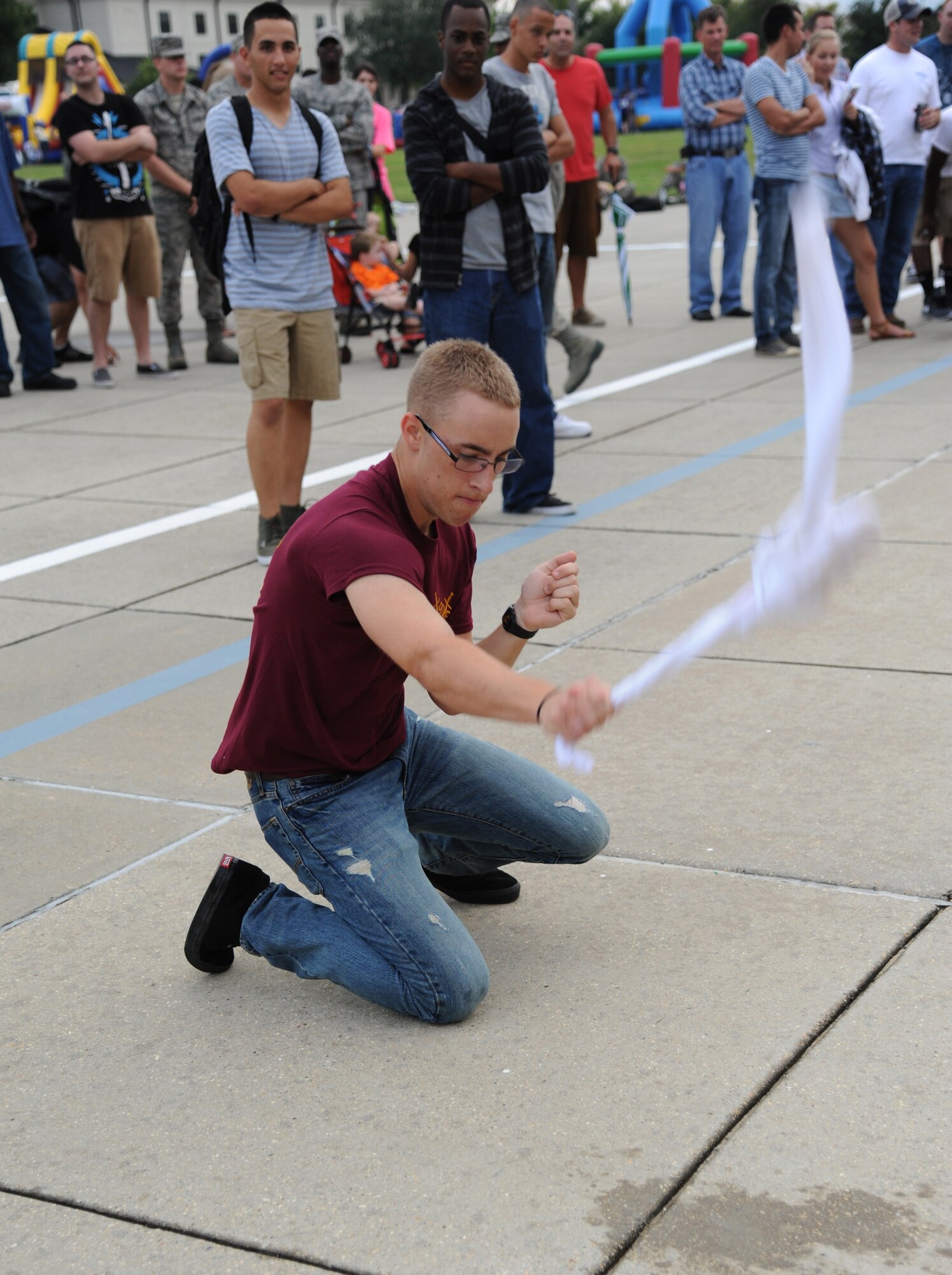 Airman Basic Christian Martin, 338th Training Squadron, slaps a frozen t-shirt against the concrete in an attempt to break the tied knot during a frozen t-shirt contest at the Air Force’s 66th birthday celebration Sept. 20, 2013, Keesler Air Force Base, Miss. The event also included a cake cutting ceremony, music, games, contests and food.  (U.S. Air Force photo by Kemberly Groue)