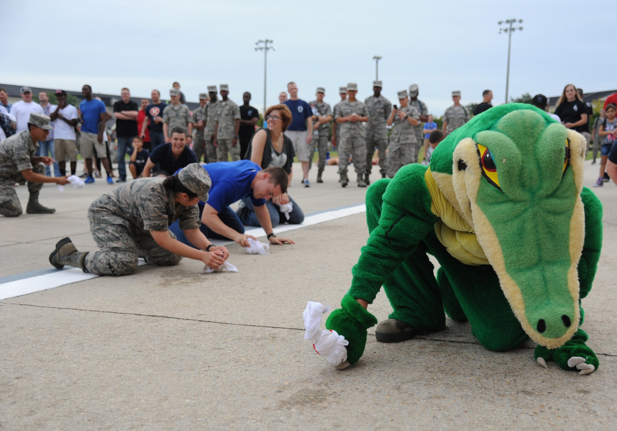 The 334th Training Squadron’s gator mascot participates in the frozen t-shirt contest along with Airmen by attempting to unfold a frozen t-shirt during the Air Force’s 66th birthday celebration Sept. 20, 2013, Keesler Air Force Base, Miss. The event also included a cake cutting ceremony, music, games, contests and food.  (U.S. Air Force photo by Kemberly Groue)