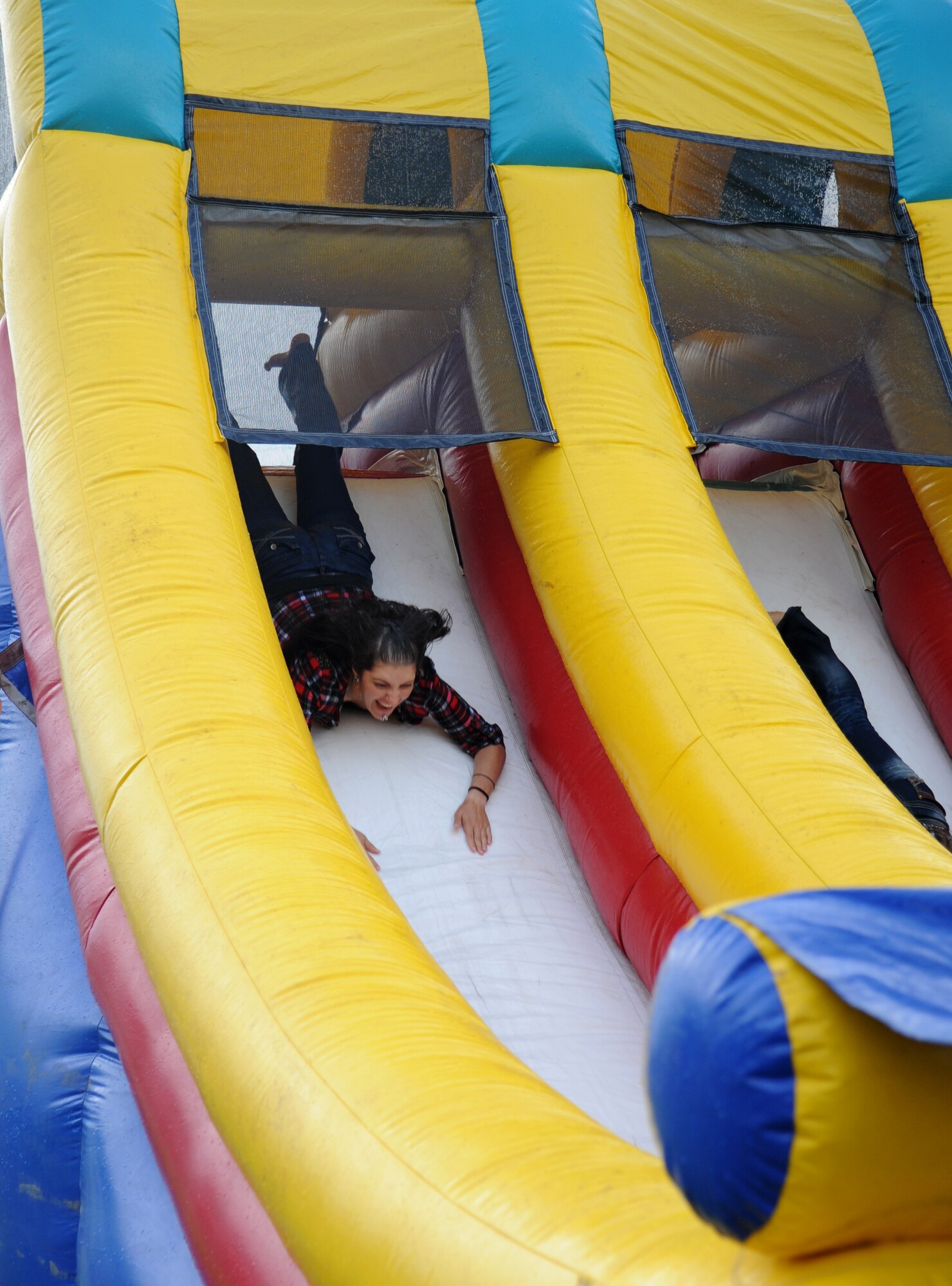 Airman 1st Class Samantha Davidson, 338th Training Squadron, slides down a blow-up obstacle course during the Air Force’s 66th birthday celebration Sept. 20, 2013,  Keesler Air Force Base, Miss.  The event also included a cake cutting ceremony, music, games, contests and food.  (U.S. Air Force photo by Kemberly Groue)