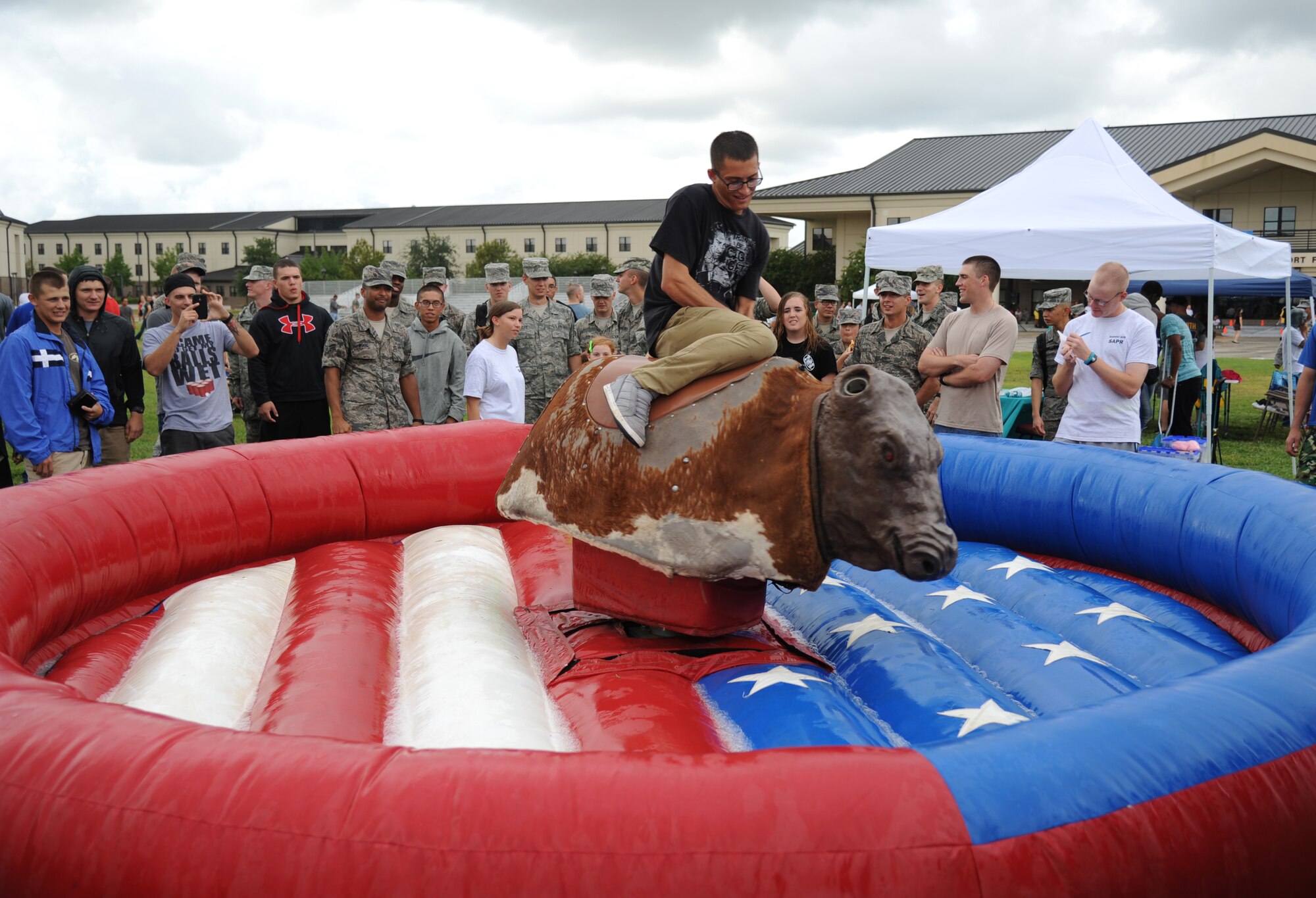 Airman Basic Duke Marino, 338th Training Squadron, rides a mechanical bull during the Air Force’s 66th birthday celebration Sept. 20, 2013, Keesler Air Force Base, Miss. The event also included a cake cutting ceremony, music, games, contests and food.  (U.S. Air Force photo by Kemberly Groue)