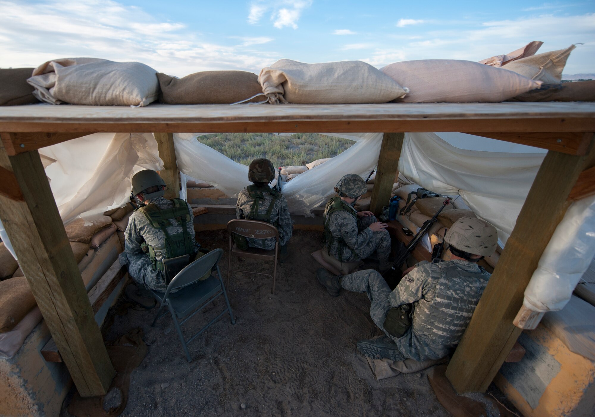 U.S. Air Force Airmen from the 726th Air Control Squadron observe their surroundings in a defensive fighting position Sept. 18, 2013, at Mountain Home Air Force Base, Idaho. Multiple DFPs were set-up around the mobile operating air base to ensure safety of all personnel on the MOAB. When enemy personnel try to infiltrate the MOAB, Airmen take the appropriate actions to protect the base. (U.S. Air Force photo by Airman 1st Class Brittany A. Chase/Released)