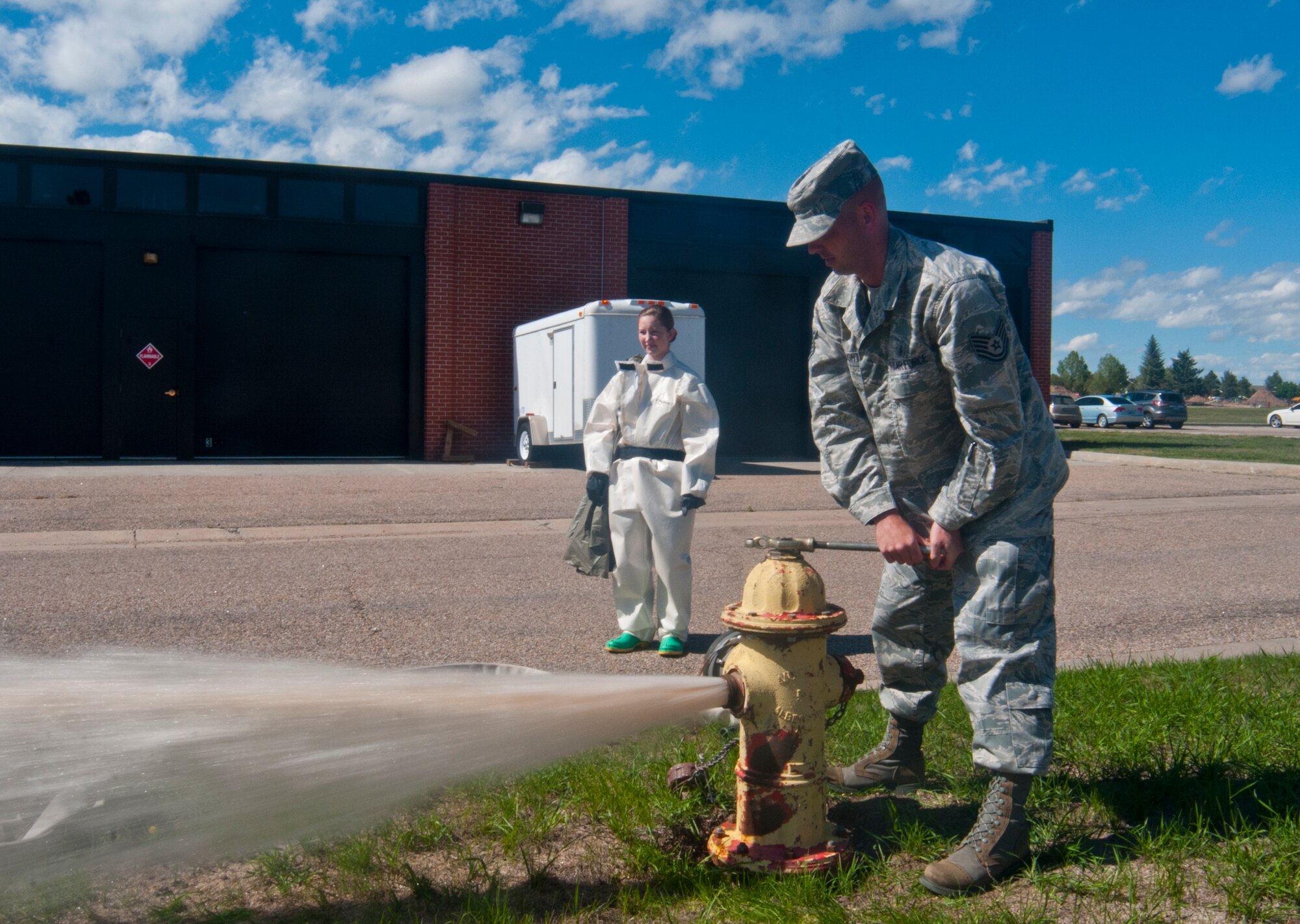 Tech. Sgt. Jeffrey Naughton, 90th Medical Group commander support staff NCOIC and in-place patient decontamination team lead, flushes the pipes of a fire hydrant near the 90th MDG Medical Treatment Facility Sept. 19, 2013. The water from the hydrant flows to a diesel-powered water heater, then to a decontamination shelter where patients exposed to harmful chemical agents can be washed with warm water. Flushing the pipes removes dirty water from the water lines so the shelter is supplied with clean water. (U.S. Air Force photo by Airman 1st Class Jason Wiese)