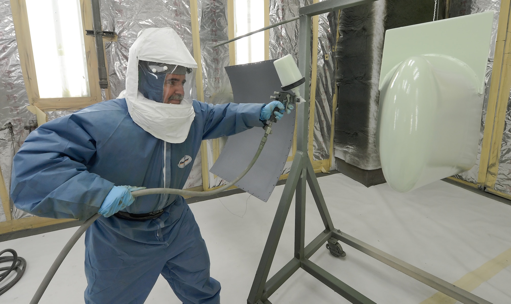 Peter Kalasky, Jr., a civilian employee of the 436th Maintenance Squadron, sprays zinc-chromate primer on aircraft parts on August 28, 2013 at Dover Air Force Base, Del. Kalasky wears full protective equipment to avoid exposure to the harmful fumes associated with his work.  (U.S. Air Force photo/Greg L. Davis)