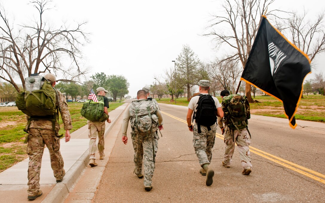 Members of the 27th Special Operations Wing participate in a ruck march to kick-off Prisoner of War/Missing in action week Sept. 16, 2013 at Cannon Air Force Base, N.M. Those who attended the ruck march took time to remember the POW/MIA personnel.(U.S. Air Force photo/Senior Airman Xavier Lockley)