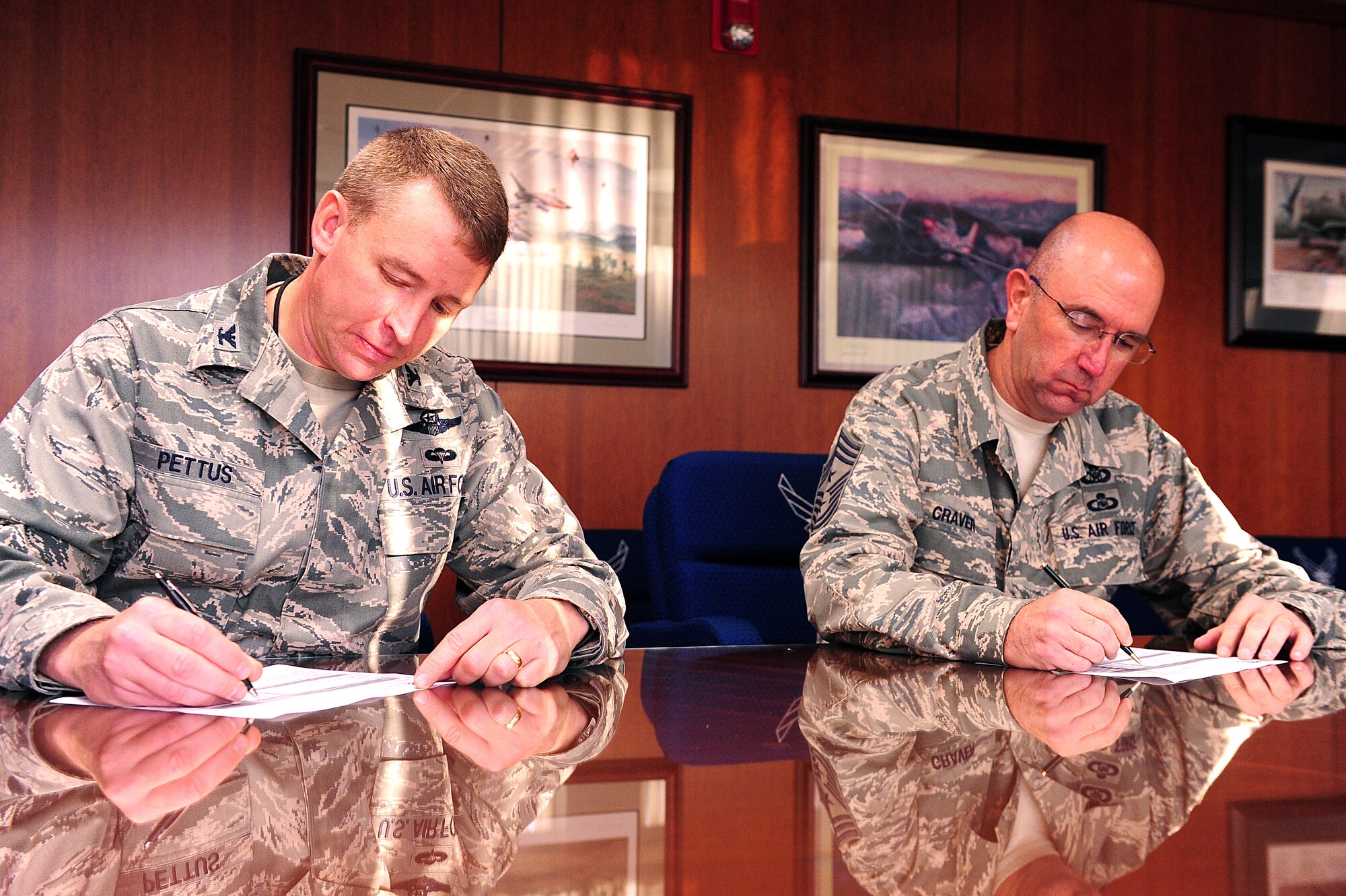 U.S. Air Force Col. Lamar Pettus, 4th Fighter Wing vice commander, and Chief Master Sgt. Jeffrey Craver, 4th FW command chief, sign their pledge forms to kick off the annual Combined Federal Campaign (CFC) at Seymour Johnson Air Force Base, Sept. 23, 2013.  The CFC provides members of Team Seymour the opportunity to donate to more than 20,000 charities.  With the campaign lasting until Oct. 28, the 4th FW goal aims to raise $230,000 this year.  (U.S. Air Force photo by Airman 1st Class Brittain Crolley)