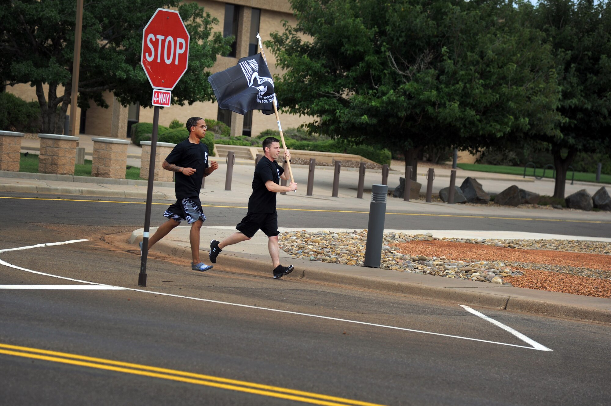 U.S. Air Force Airmen finish the 24-hour Prisoner of War/Missing in Action Vigil Run by carrying the flag to the retreat ceremony Sept. 20, 2013 at Cannon Air Force Base, N.M.  This event was held to honor and remember POW and MIA service members.  (U.S. Air Force photo/Senior Airman Jette Carr)