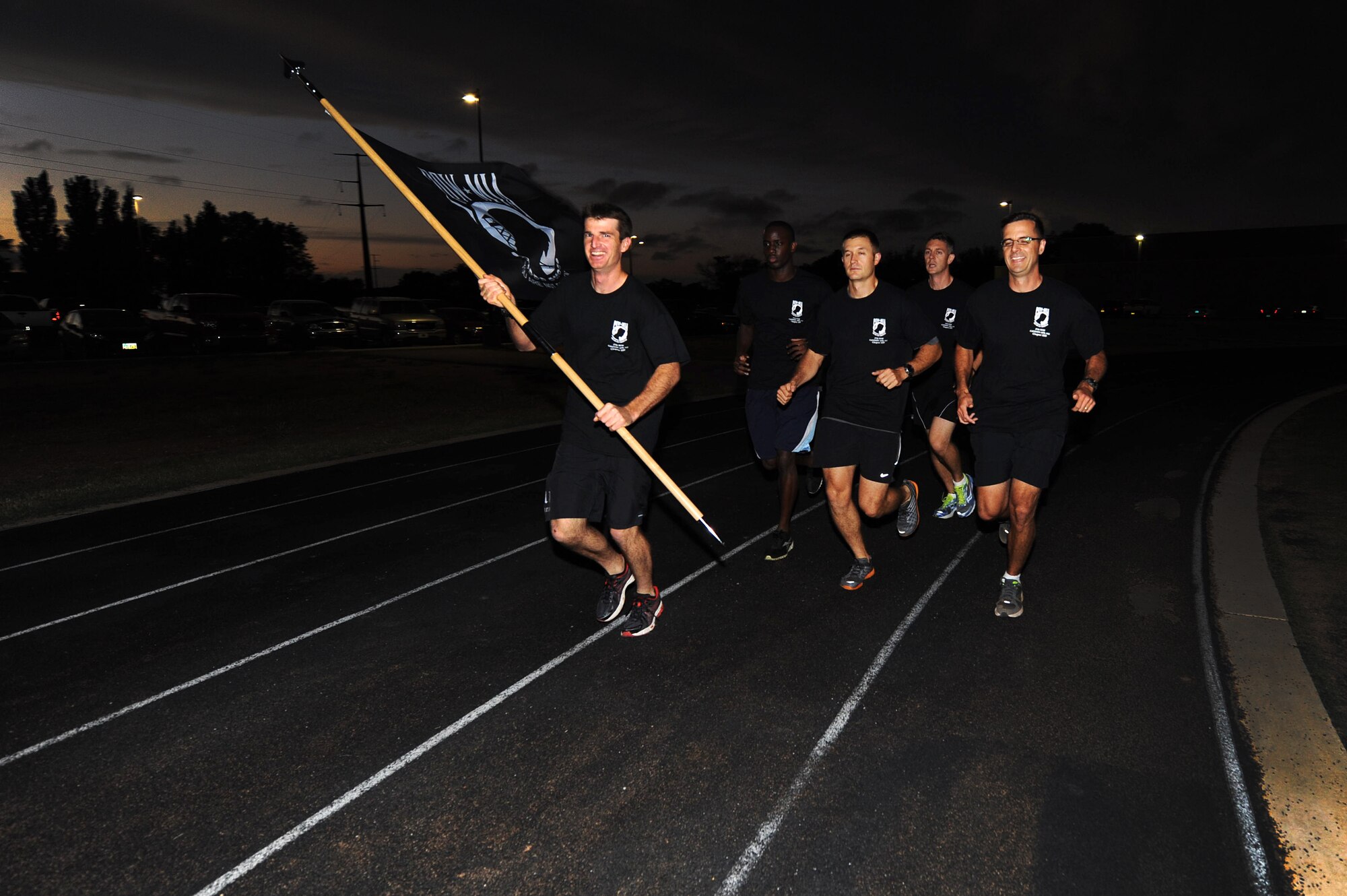 U.S. Air Force Air Commandos carry the Prisoner of War/Missing in Action flag around the track during the 24-hour POW/MIA Vigil Run Sept. 19, 2013 at Cannon Air Force Base, N.M.  This event was held to honor and remember POW and MIA service members.  (U.S. Air Force photo/Senior Airman Jette Carr)