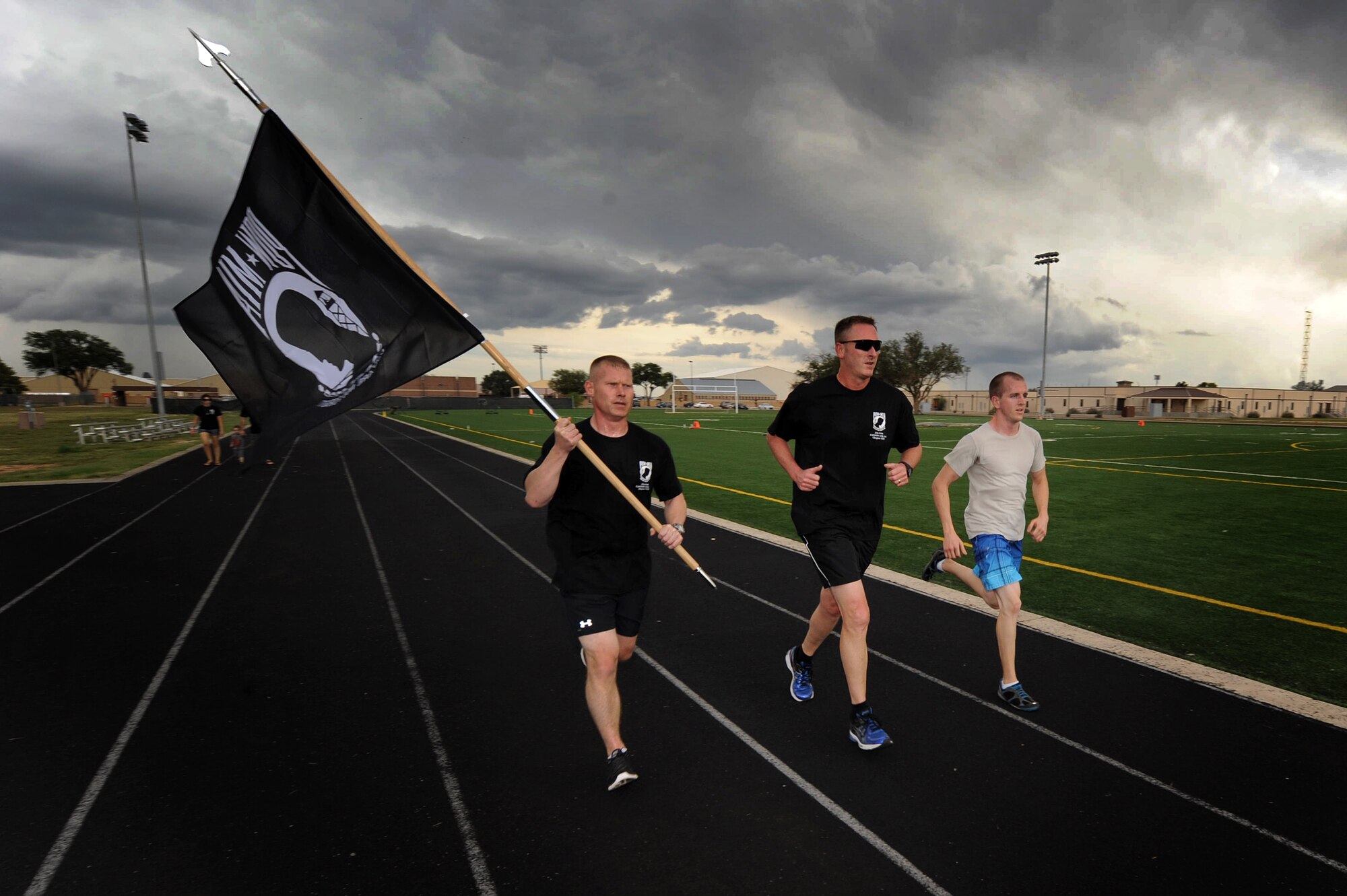 U.S. Air Force Air Commandos carry the Prisoner of War/Missing in Action flag around the track during the 24-hour POW/MIA Vigil Run Sept. 19, 2013 at Cannon Air Force Base, N.M.  This event was held to honor and remember POW and MIA service members.  (U.S. Air Force photo/Senior Airman Jette Carr)