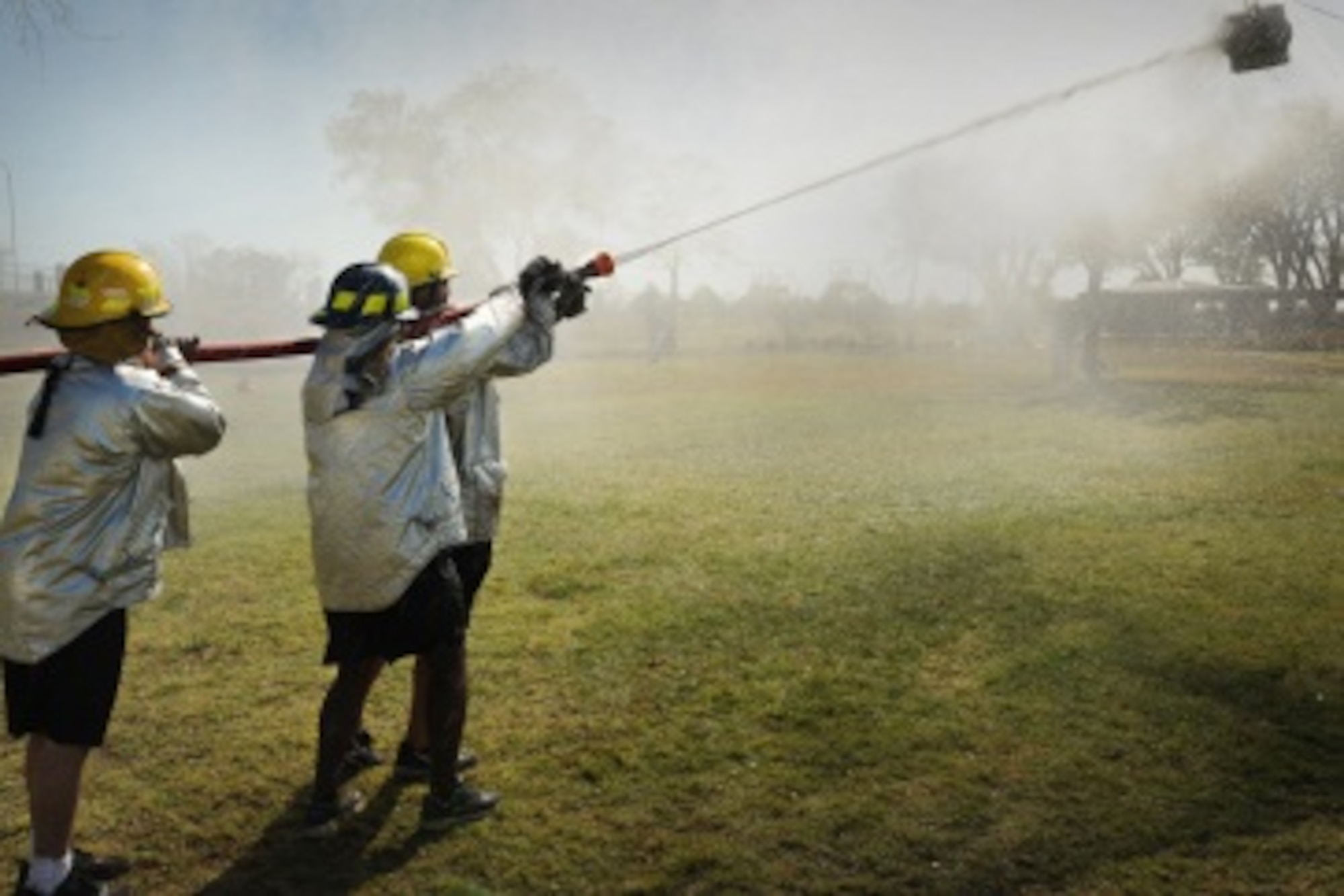 Competitors hit their target with a fire hose during the 14th Annual Fire Muster Oct. 19, 2012 at Cannon Air Force Base, N.M. This friendly competition is one of the many events held during Fire Prevention Week each year. (U.S. Air Force photo/Senior Airman Jette Carr)