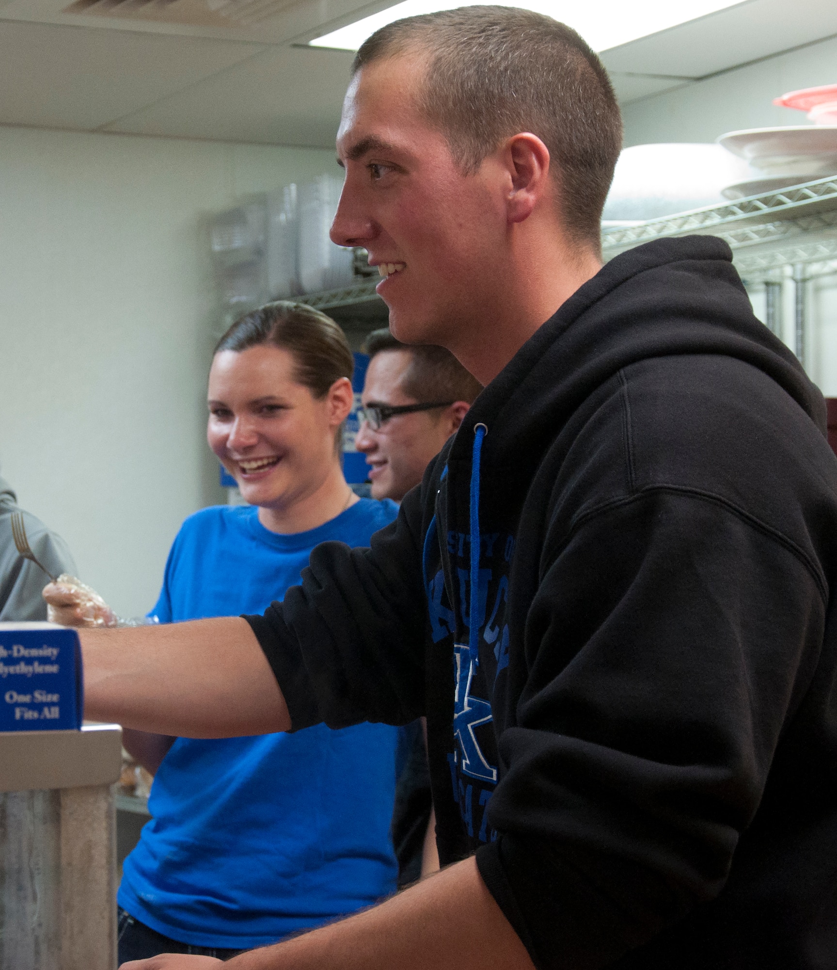 Senior Airman Jameson McBride, 790th Missile Security Forces Squadron, serves up a piece of Texas toast to the homeless of Cheyenne, Wyo., Sept. 18, 2013. McBride was with a group of eight Airmen who volunteered to serve food at the Comea House Homeless Shelter. (US Air Force photo by Airman 1st Class Brandon Valle)