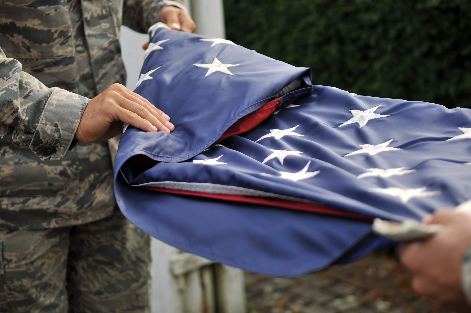 Members of the Team Mildenhall Honor Guard fold the U.S. flag during a retreat ceremony Sept. 20, 2013, on RAF Mildenhall, England. RAF Mildenhall held a ceremonial retreat in remembrance of the U.S. service members held as prisoners of war and those missing in action. Retreat is a long-standing tradition honoring the flag and signaling the end of the duty day. (U.S. Air Force photo by Airman 1st Class Kyla Gifford/Released)
