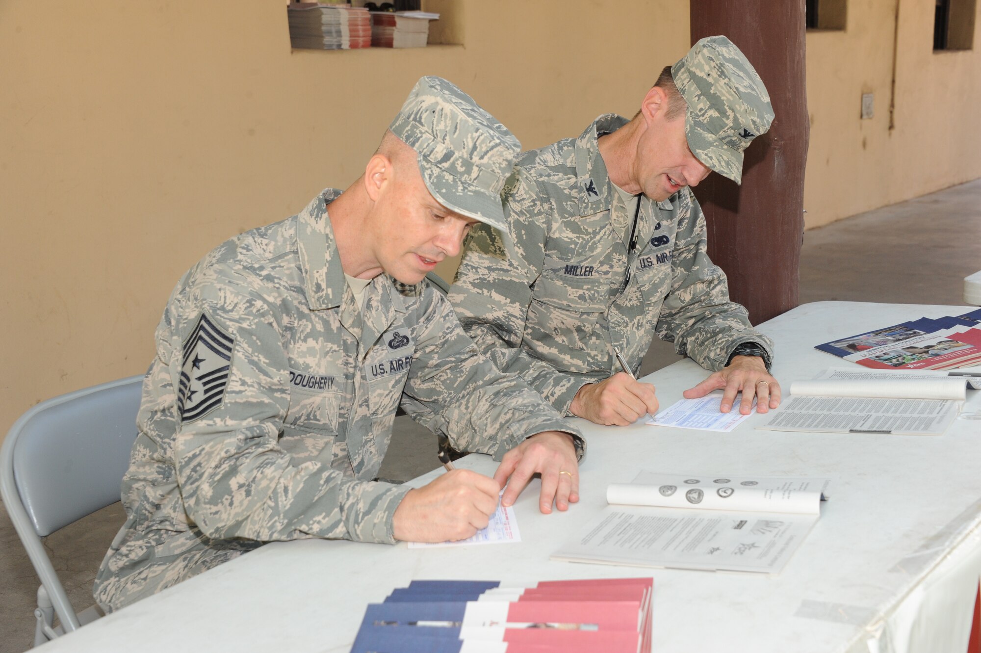 Chief Master Sgt. John Dougherty (left), command chief master sergeant for the Air Force Nuclear Weapons Center and the 377th Air Base Wing, and Col. Tom Miller, 377th ABW commander, sign pledge cards Sept. 17 to kick off the Combined Federal Campaign at Kirtland.  The base aims to raise $400,000 during Combined Federal Campaign, which runs to Nov. 17. (Photo by Dennis Carlson)


