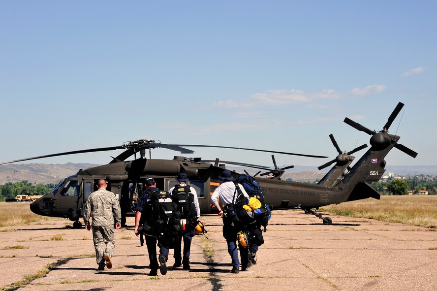 Colorado and national civil search and rescue teams from around the country prepare to board a UH-60 Blackhawk helicopter assigned to Charlie Company, 5th Battalion, 159th Aviation Regiment, Wyoming National Guard, in order to help Coloradoans that have been effected by the flood waters from the Big Thompson River just west of Fort Collins Colo. Sept. 17, 2013.  What is being dubbed “Operation Centennial Raging Waters” is likely the biggest rotary-wing airlift mission since Hurricane Katrina and has become a complete neighbors helping neighbors effort with state national guards from Colorado and Wyoming, Active duty units from Colorado as well as search and rescue units from all over the country. (U.S. Air National Guard photo by Tech. Sgt. Wolfram M. Stumpf/RELEASED)