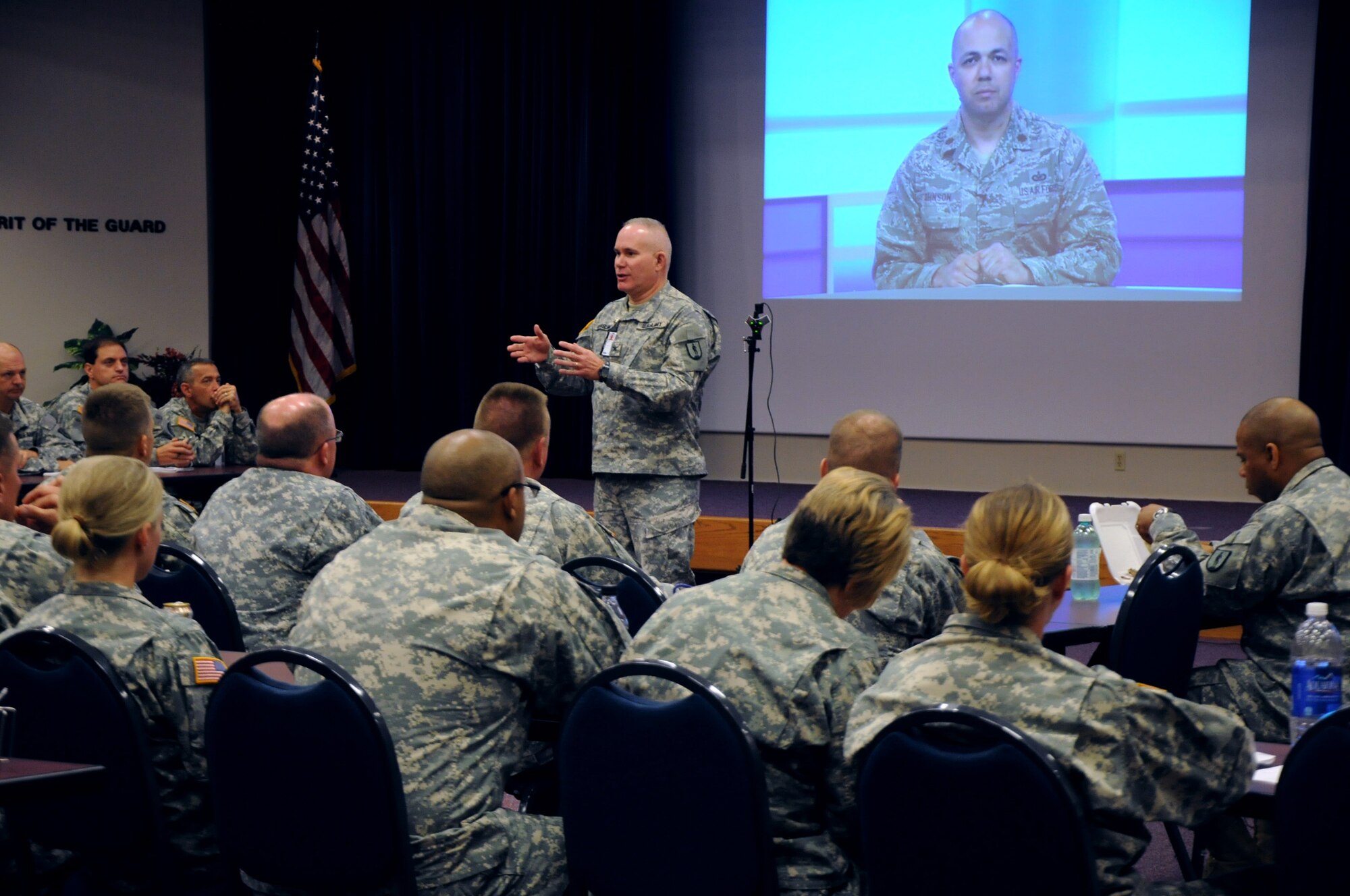 LITTLE ROCK, Ark. - Army COL Timothy Keasling, commandant of the National Guard's LaVern E. Weber Professional Education Center, gives an overview here, Sept. 16, 2013, to about 50 Army National Guard Soldiers during a live HD broadcast of U.S. Air Force Maj. Gabe Johnson, deputy commander of the I.G. Brown Training and Education Center (on screen). Johnson taught a professional development seminar about Personal Accountability from the I.G. Brown Training and Education Center in Tennessee. (U.S. Army National Guard courtesy photo/Released)