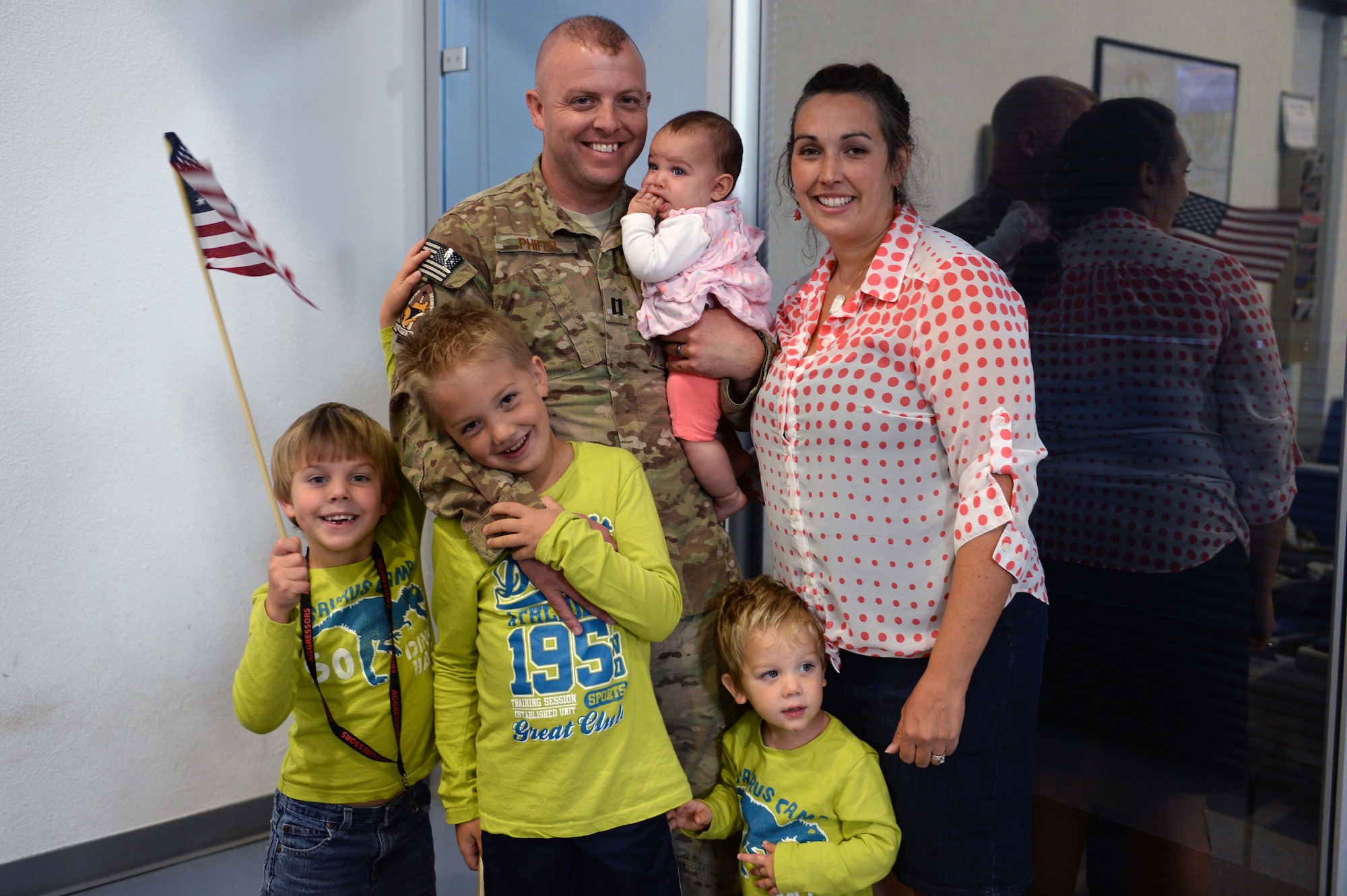 SPANGDAHLEM AIR BASE, Germany — U.S. Air Force Capt. Jeremy Phifer, 480th Aircraft Maintenance Unit officer in charge, gathers with his family Sept. 21, 2013, at a homecoming celebration upon returning from a six-month deployment to Southwest Asia. Families were united with more than 150 Airmen who left in April. (U.S. Air Force photo by Senior Airman Alexis Siekert/Released)