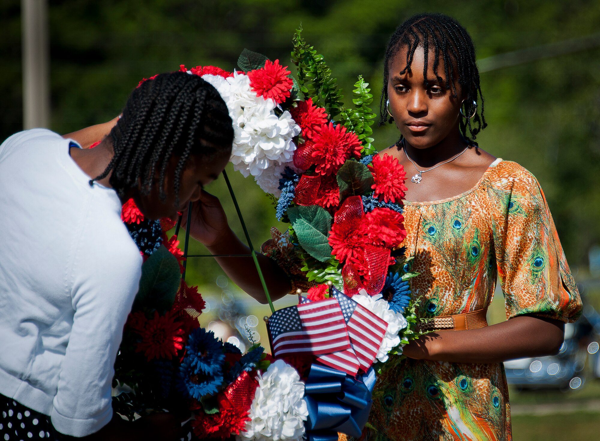 Sophia Williams and Kelisa McChester, from Addie R. Lewis Middle School, present a remembrance wreath at the POW/MIA event Sept. 20 at the Air Force Armament Museum. The ceremony paid tribute to those military members who have yet to return home from defending America. The event featured tributes, guest speakers and honor guard procedures. (U.S. Air Force photo/Samuel King Jr.)