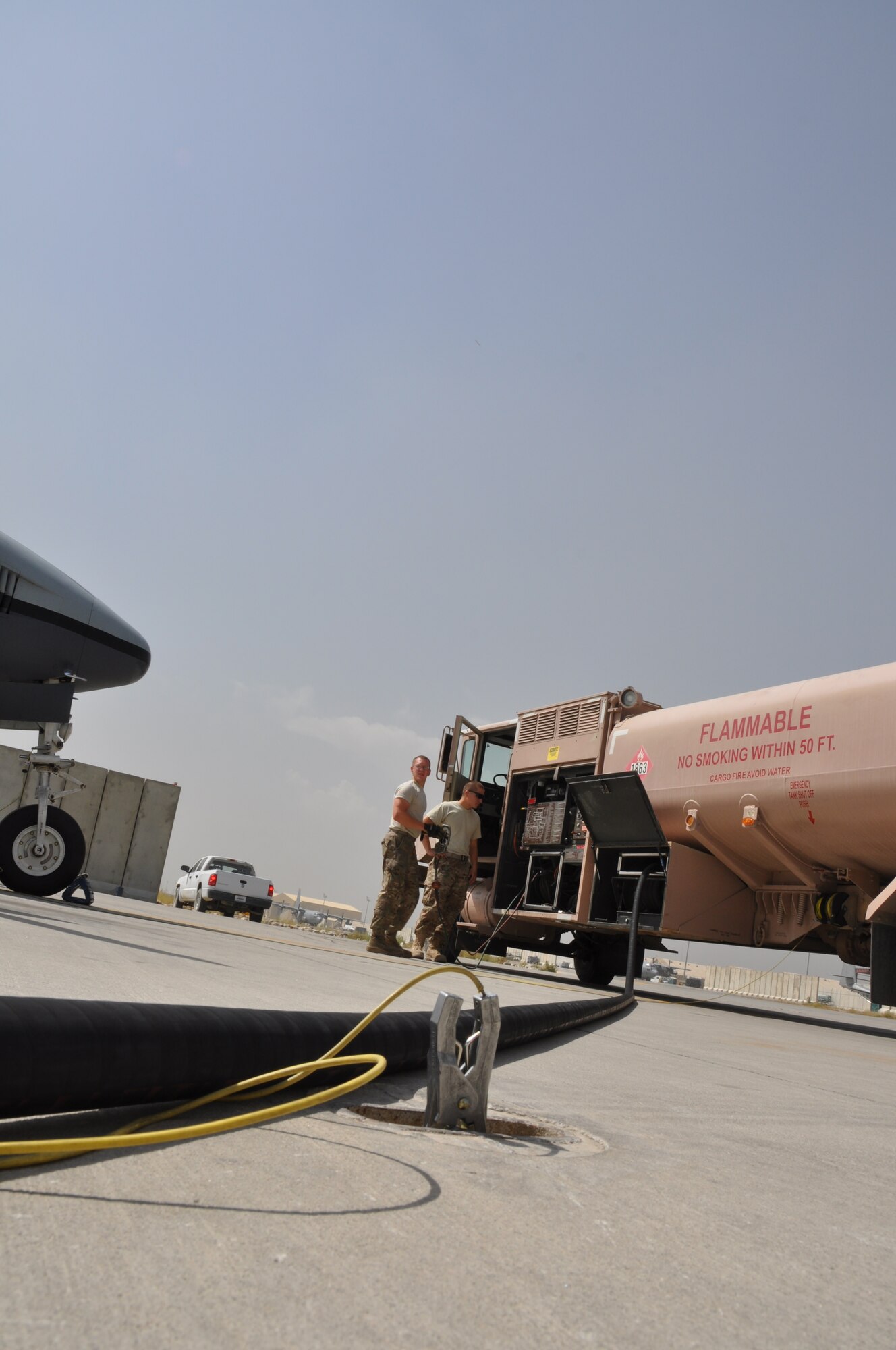 Staff Sgt. Andrew Mitalski, 455th Expeditionary Logistics Readiness Squadron distribution supervisor, deployed from Shaw Air Force Base, S.C., and a native of Hudson, Ohio, works as expeditor to assist Senior Airman Robert Ellis, 455th ELRS refueling unit operator, deployed from Holloman Air Force Base, N.M., and native of Gladstone, Mo., during a fuels run at Bagram Airfield, Afghanistan, Sept. 18, 2013. (U.S. Air Force photo/Tech. Sgt. Rob Hazelett)