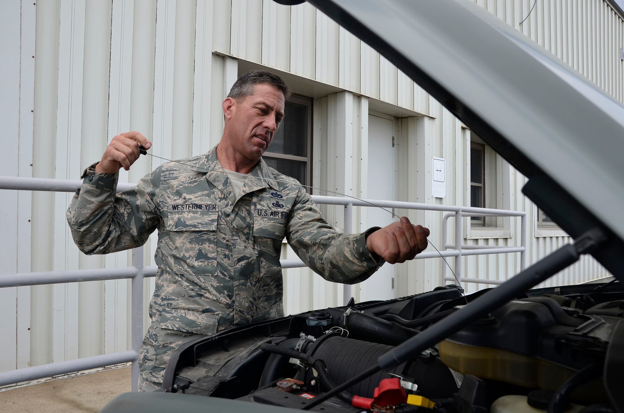 WRIGHT-PATTERSON AIR FORCE BASE, Ohio - Senior Master Sgt. John Westermeyer, 87th Aerial Port Squadron passenger services superintendent, looks under the hood of a Bobtail-Tug, a pulling support vehicle used for towing, to ensure it is serviceable during the Aug. 3 unit training assembly. (U.S. Air Force photo/Master Sgt. Charlie Miller)