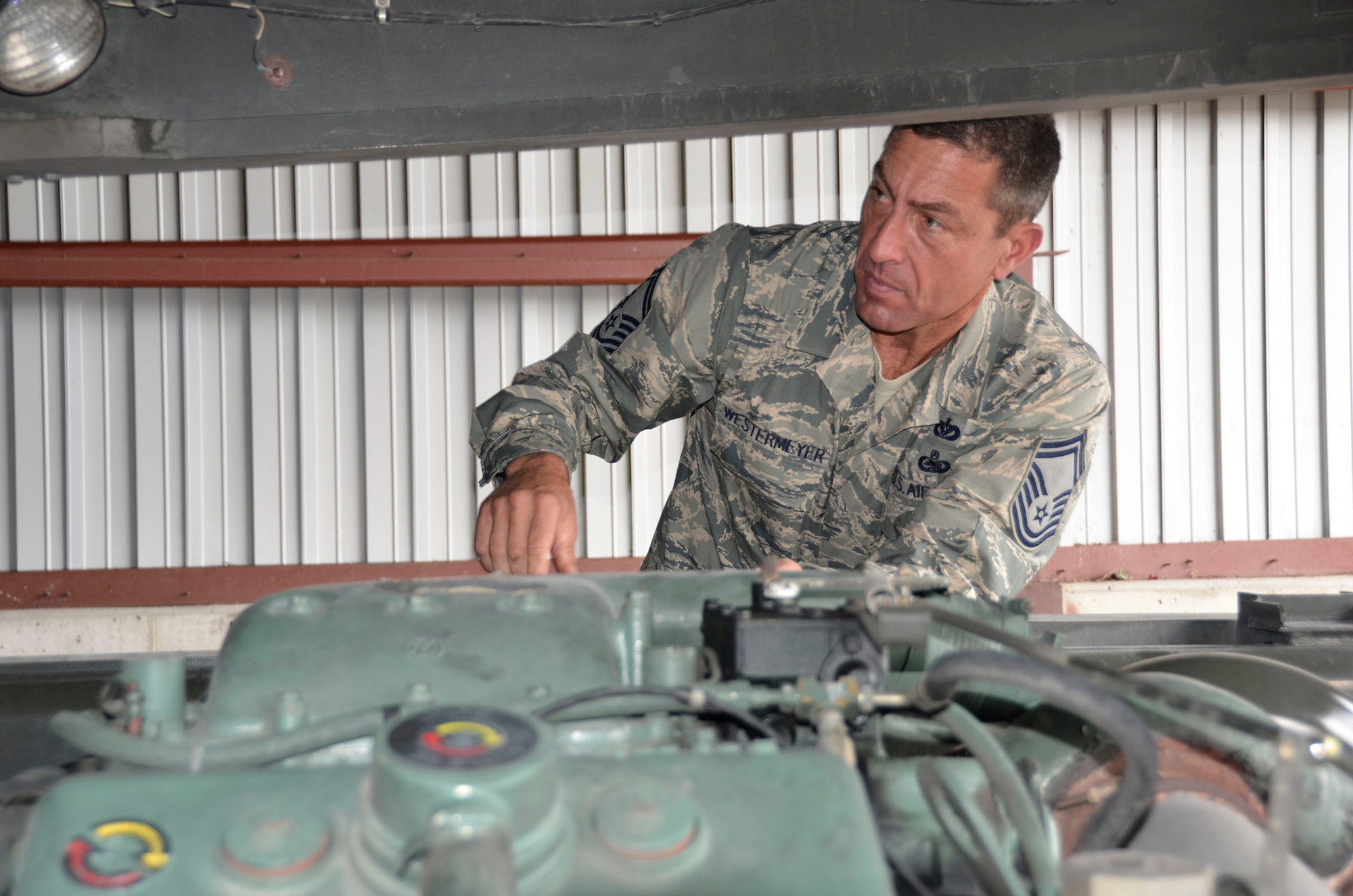 WRIGHT-PATTERSON AIR FORCE BASE, Ohio - Senior Master Sgt. John Westermeyer, 87th Aerial Port Squadron passenger services superintendent, checks the engine of a 60K loader, a vehicle that can load and unload cargo from all military and commercial cargo aircraft. (U.S. Air Force photo/Master Sgt. Charlie Miller)