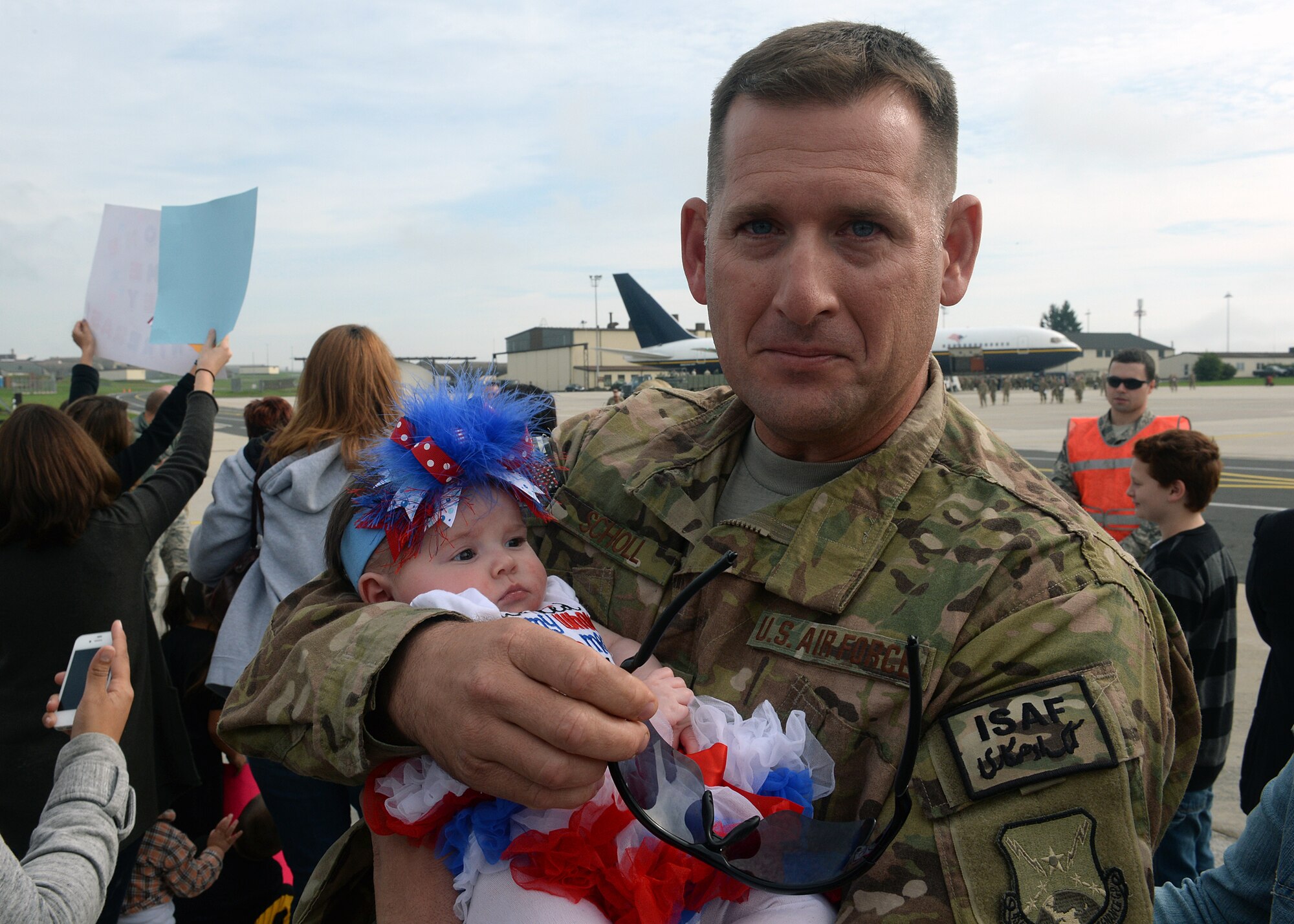 SPANGDAHLEM AIR BASE, Germany -- U.S. Air Force Senior Master Sgt. Todd Scholl, 52nd Aircraft Maintenance Squadron, holds his daughter Evelyn for the first time here Sept. 21, 2013. Evelyn was born 86 days ago while Scholl was still in southwest Asia supporting Operation Enduring Freedom. (U.S. Air Force photo by Staff Sgt. Daryl Knee/Released)