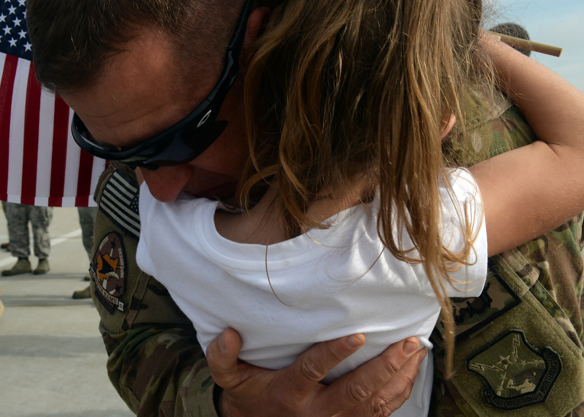 SPANGDAHLEM AIR BASE, Germany -- U.S. Air Force Senior Master Sgt. Todd Scholl, 52nd Aircraft Maintenance Squadron, hugs his daughter Brooklyn here Sept. 21, 2013, after returning from a deployment to southwest Asia supporting Operation Enduring Freedom. Scholl's children painted welcome-home signs and wore decorated clothing for his return. (U.S. Air Force photo by Staff Sgt. Daryl Knee/Released)