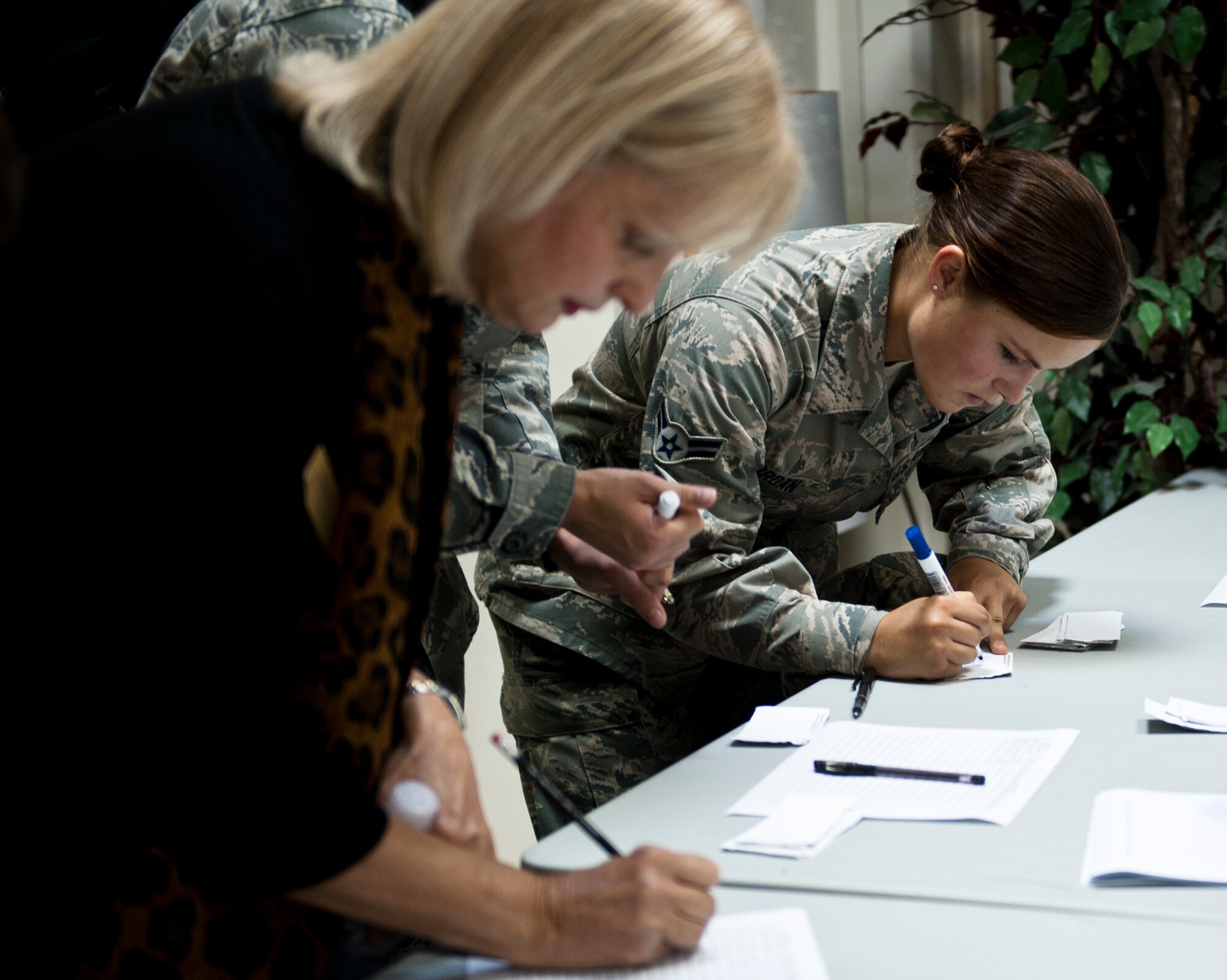 Airman 1st Class Kayla Jordan, 39th Logistics Readiness Squadron material management apprentice, signs her nametag for the Caring For People Forum Sept. 20, 2013, at Incirlik Air Base, Turkey. The Caring For People Forum is an Air Force initiative to help improve quality of life within the Air Force family. (U.S. Air Force photo by Senior Airman Daniel Phelps/Released)