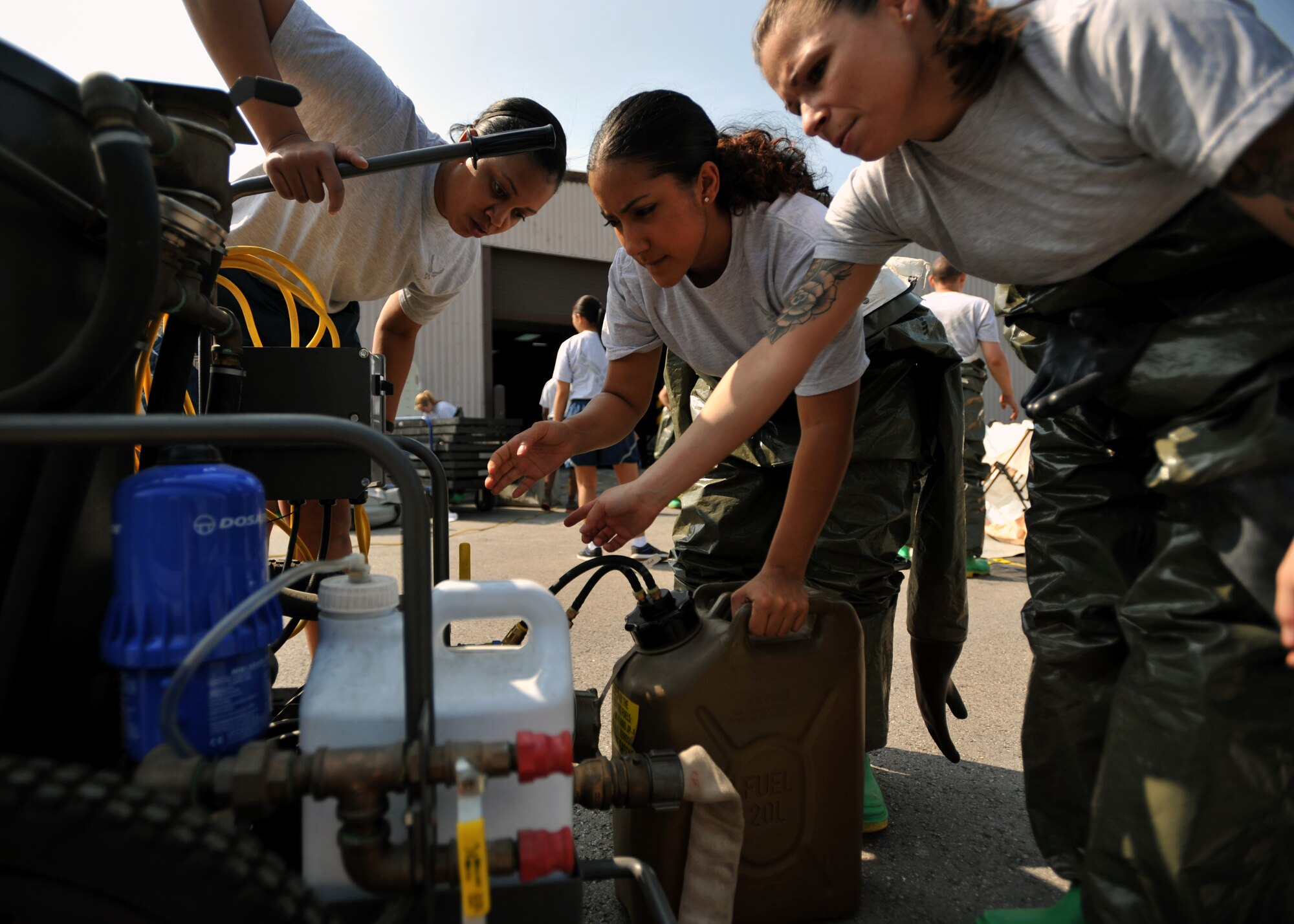 Maj. Stephanie King, left, 51st Aerospace Medicine Squadron Optometry Flight commander, and Staff Sgts. Kanise Rankins and Michelle Fleet, both 51st Dental Squadron dental technicians, operate a water heater during an in-place patient decontamination training course at Osan Air Base, Republic of Korea, Sept. 19, 2013. The water heater connects to the pop-up decontamination facility and heats the water that the facility uses to process decontaminated patients. (U.S. Air Force photo/Senior Airman Siuta B. Ika)