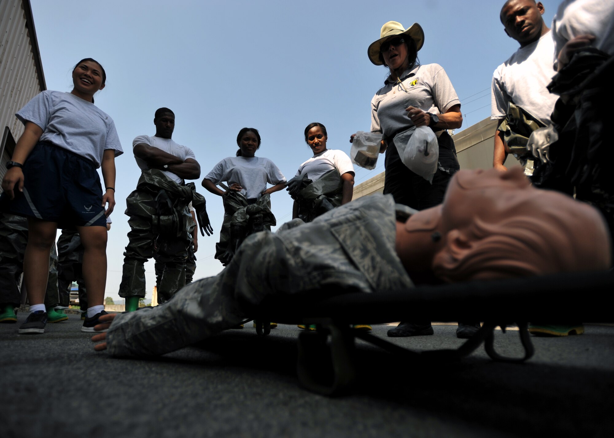 Members of the 51st Medical Group gather around a training dummy while Theresa Casey, decontamination instructor and consultant with DECON LLC, explains steps to take during an in-place patient decontamination training course at Osan Air Base, Republic of Korea, Sept. 19, 2013. The 22 participants in the training course learned all of the necessary steps in processing decontaminated patients, as well as how to set up the pop-up decontamination facility. (U.S. Air Force photo/Senior Airman Siuta B. Ika)