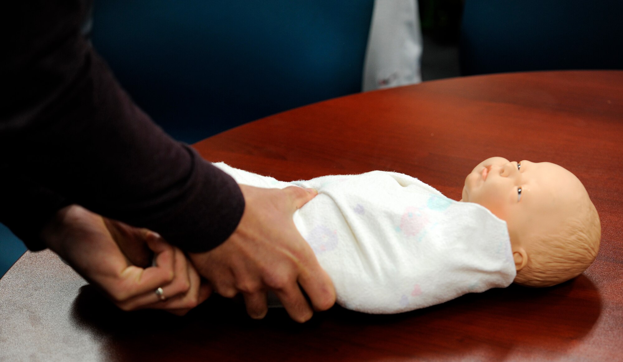 U.S. Air Force Staff Sgt. Zed Harbort, 35th Aircraft Maintenance Squadron flightline expeditor, swaddles a model infant during the Dads 101 class at Misawa Air Base, Japan, Sept. 19, 2013. The intent of Dads 101 is to teach fathers about proper infant care as well as the changes their wife will go through. The Dads 101 class has become mandatory for any male wanting to take paternity leave. For more information, contact your first sgt. or commander about the WEASEL NOTAM – 35FW-13-15 Paternity Leave and Family Enhancement. (U.S. Air Force photo by Airman 1st Class Kaleb Snay)