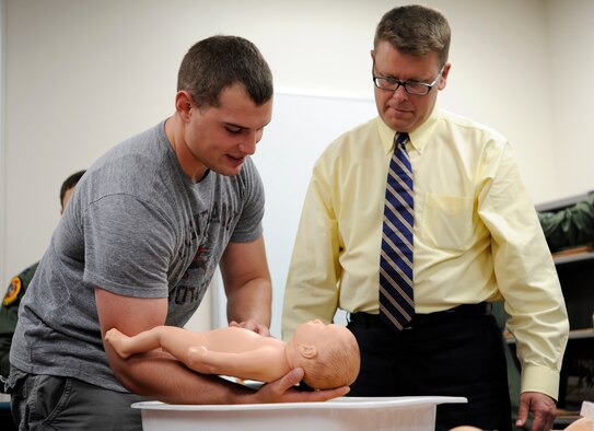Jim Bibbee, 35th Fighter Wing community support coordinator, right, instructs Senior Airman Evan Welsh, 35th Maintenance Squadron munitions controller, the proper way to hold a baby while bathing them during the Dads 101 class at Misawa Air Base, Japan, Sept. 19, 2013. The goal of Dads 101 is to set fathers up for success and educate them about their newborn child. The Dads 101 class has become mandatory for any male wanting to take paternity leave. For more information, contact your First Sgt. or commander about the WEASEL NOTAM – 35FW-13-15 Paternity Leave and Family Enhancement.  (U.S. Air Force photo by Airman 1st Class Kaleb Snay)