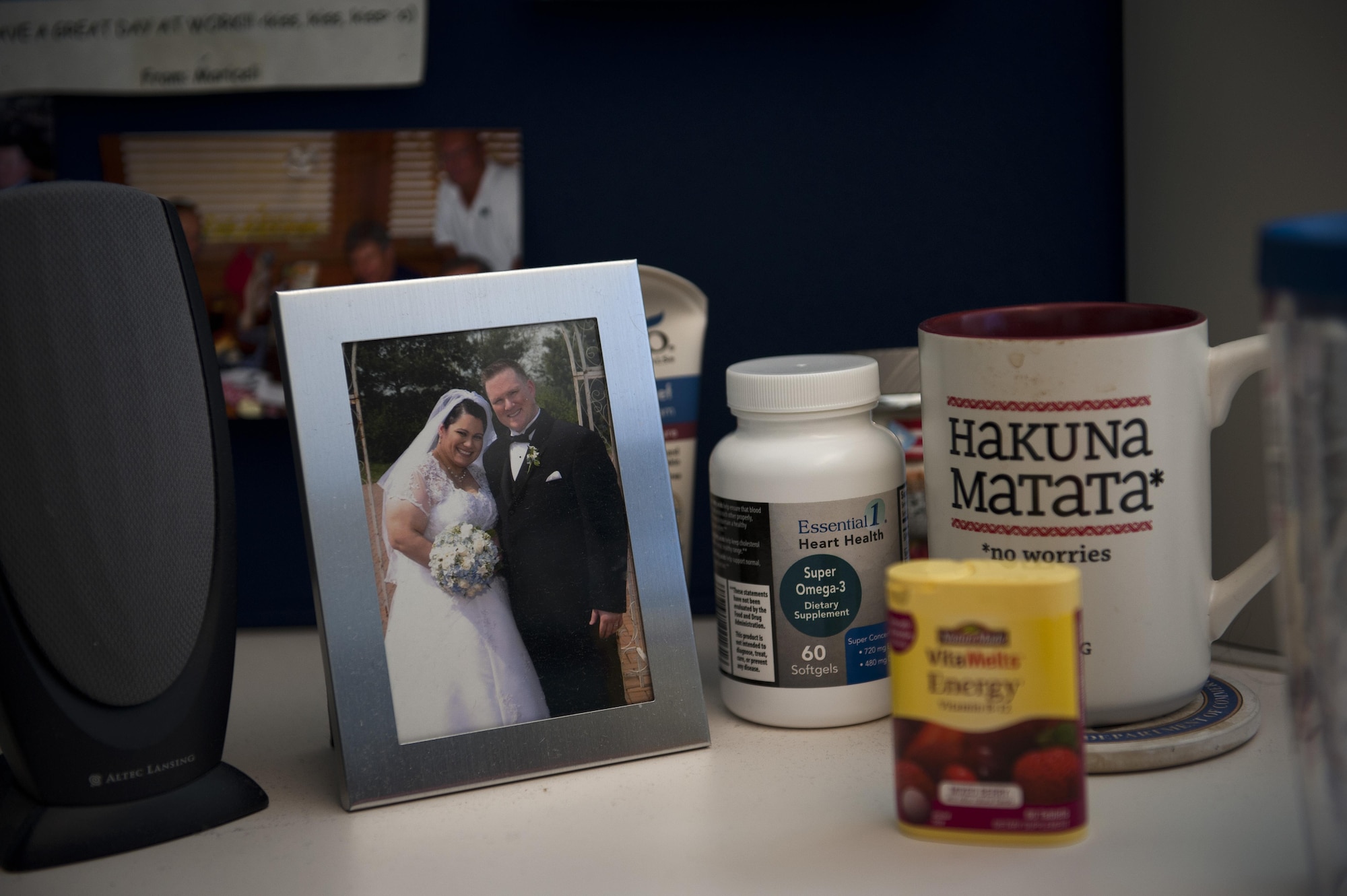 A picture of Heath Johnson and his wife, Mariceli Santiago, sits on his desk at work, along with vitamins. Johnson has lost 91 lbs since Feb. 25, 2013. 
