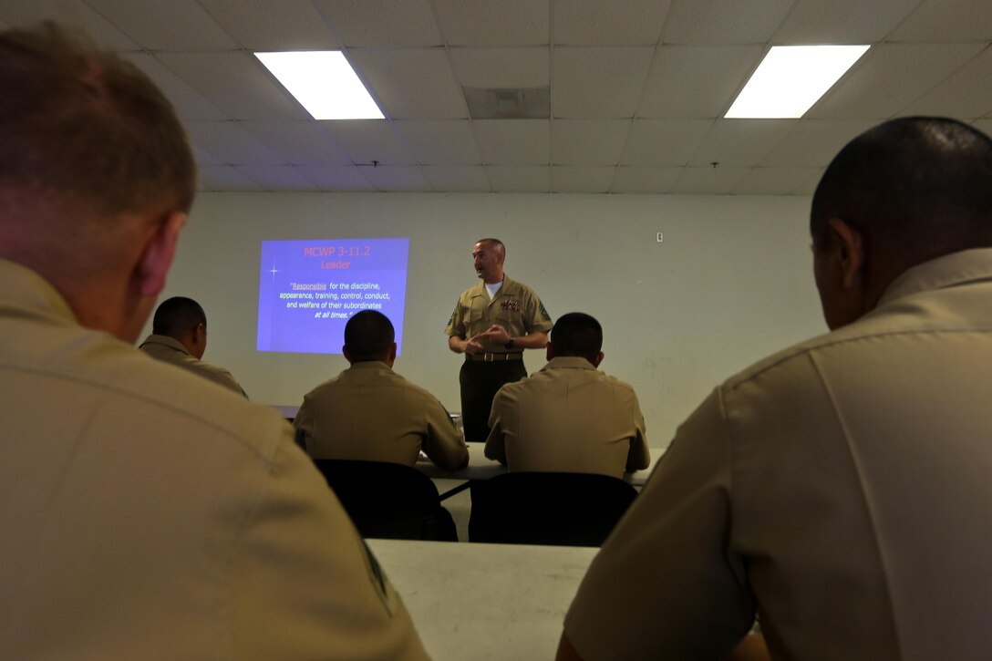 First Sgt. Jason Politte, Headquarters Company first sergeant, 5th Marine Regiment, talks to noncommissioned officers during a weekly professional military education session here, Sept. 20, 2013. Politte, a native of Papillion, Neb., said the regiment's focus on small-unit leaders benefits not only the Marine Corps but also society. His PME focused on the NCOs' roles as mentors and leaders with their junior Marines.