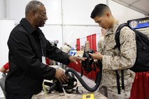 Don Holman of Infantry Weapons Systems describes the Joint Service General Purpose Mask to Cpl. Charlie Nguyen during the Modern Day Marine Expo Sept. 24 at Marine Corps Base Quantico, Va. At the expo, Marines can see the gear Marine Corps Systems Command program offices are fielding and will field in the future. 