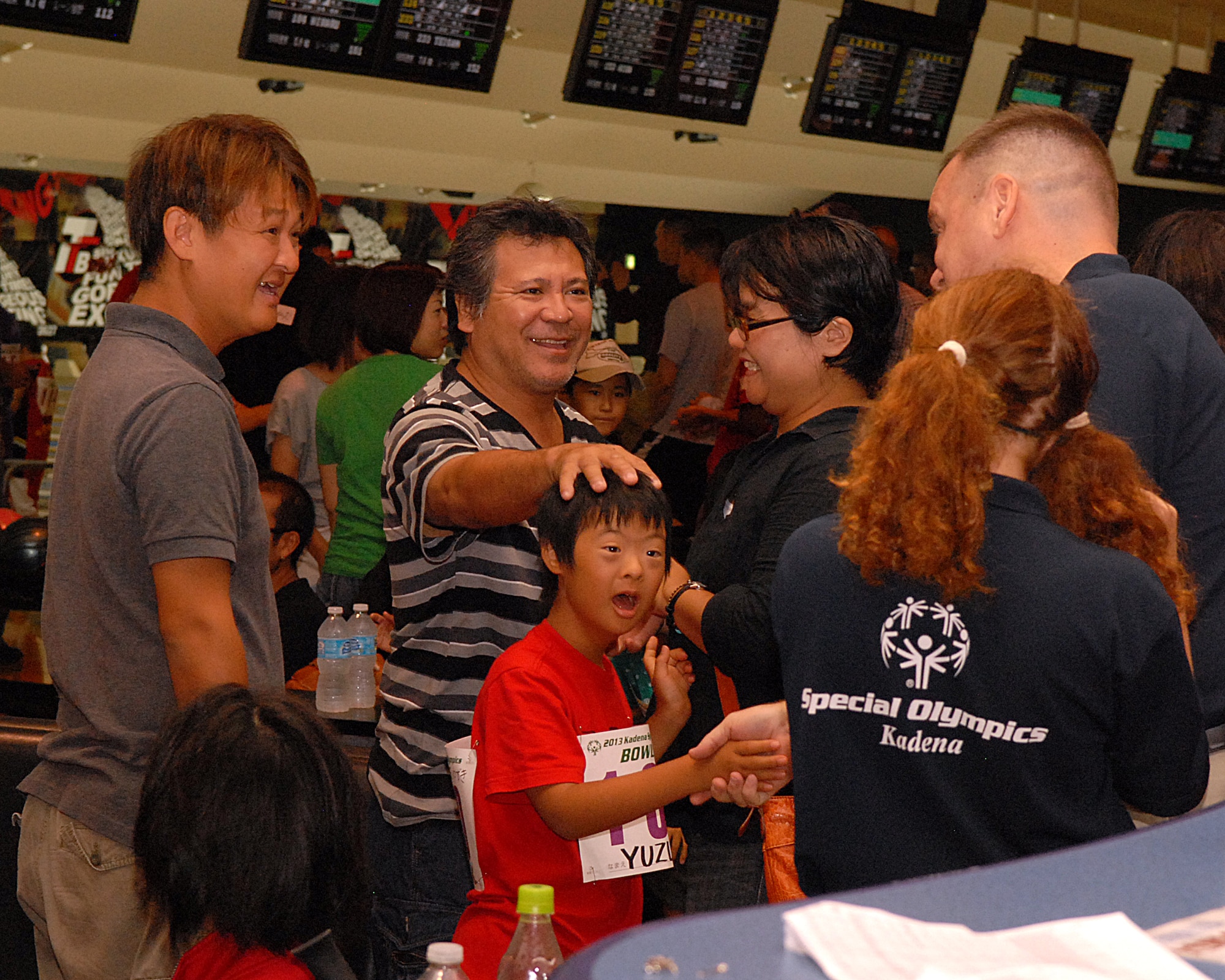 U.S. Air Force Col. Brian McDaniel (right), 18th Wing vice commander, greets a participant at the Kadena Special Olympics bowling event in Mihama, Okinawa, Japan, Sept. 21, 2013. More than 230 participants bowled throughout the event as family and volunteers cheered on. This bowling event was one of several to precede the KSO game day which is scheduled for Nov. 2. (U.S. Air Force photo by Staff Sgt. Lauren Snyder)