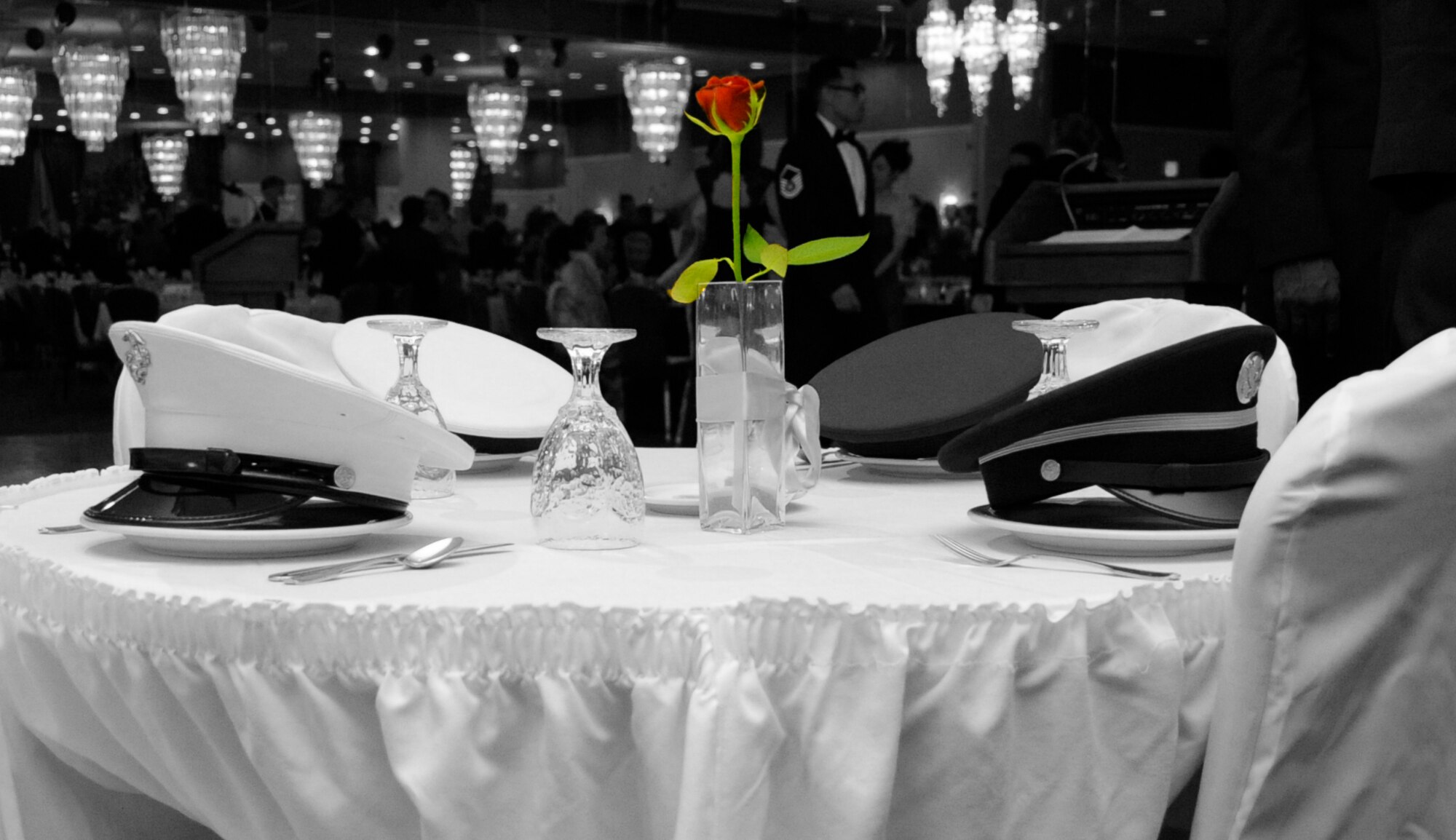 A small table is set aside honoring comrades that are Prisoner of War or Missing in Action during the 66th Annual U.S. Air Force Ball at Misawa Air Base, Japan, Sept. 21, 2013. The tablecloth is white symbolizing their purity. A candle burns for their unselfish courage and valor, and a single red rose reminds us of the families and loved ones who continue to have faith. They are lost, but not forgotten. (U.S. Air Force photo illustration by Airman 1st Class Kaleb Snay)